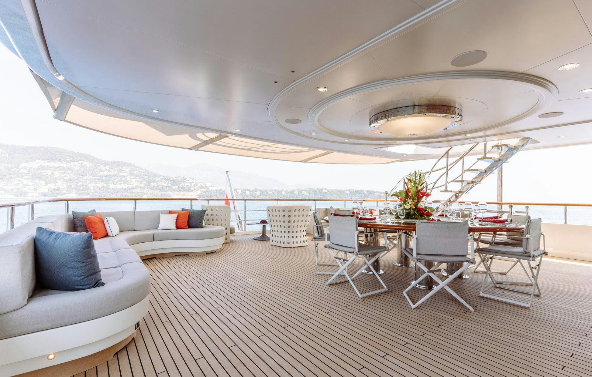 a large room with a table and chairs and a large body of water aboard HEMABEJO Yacht for Charter
