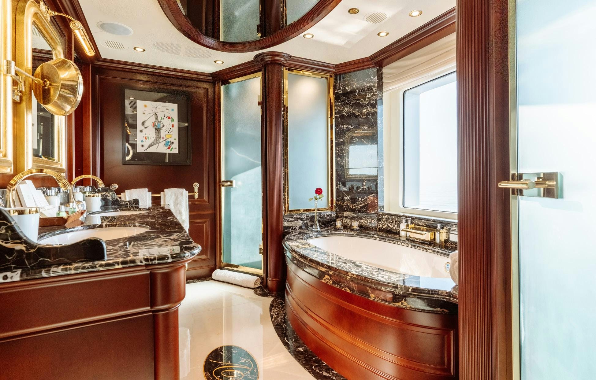 a bathroom with a tub sink and mirrors aboard HEMABEJO Yacht for Charter