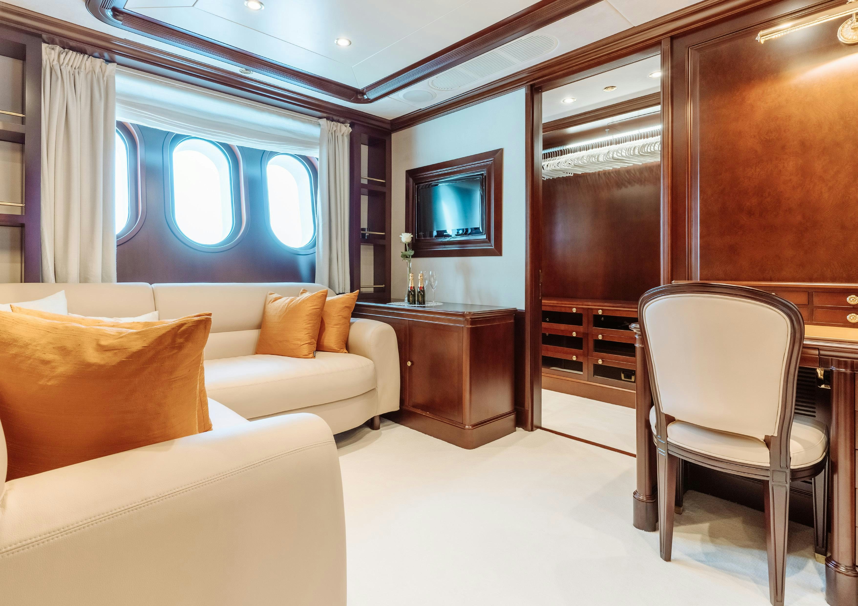 a living room with a couch and a television aboard HEMABEJO Yacht for Charter