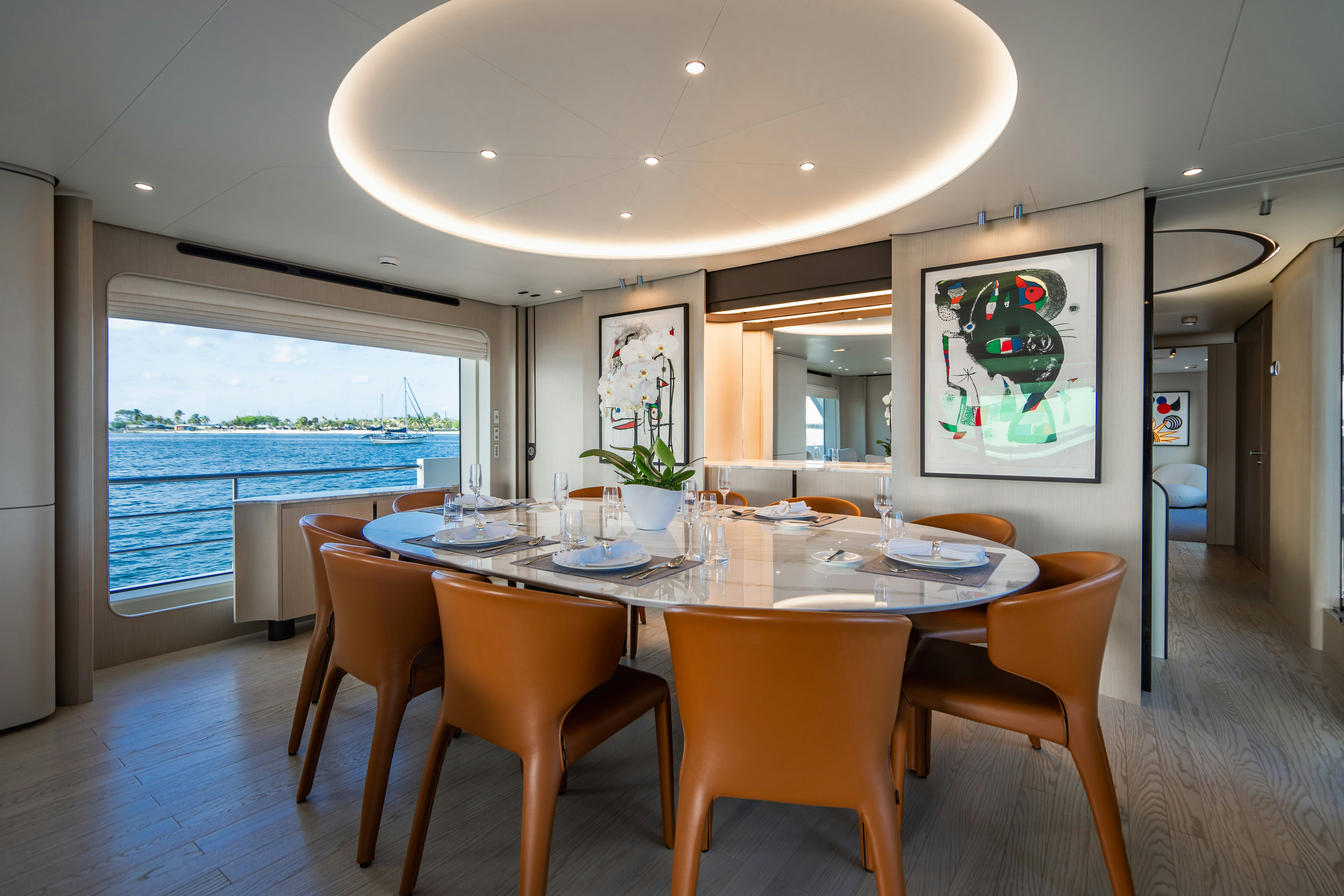 a dining table with chairs and a large window aboard CARPE DIEM Yacht for Charter
