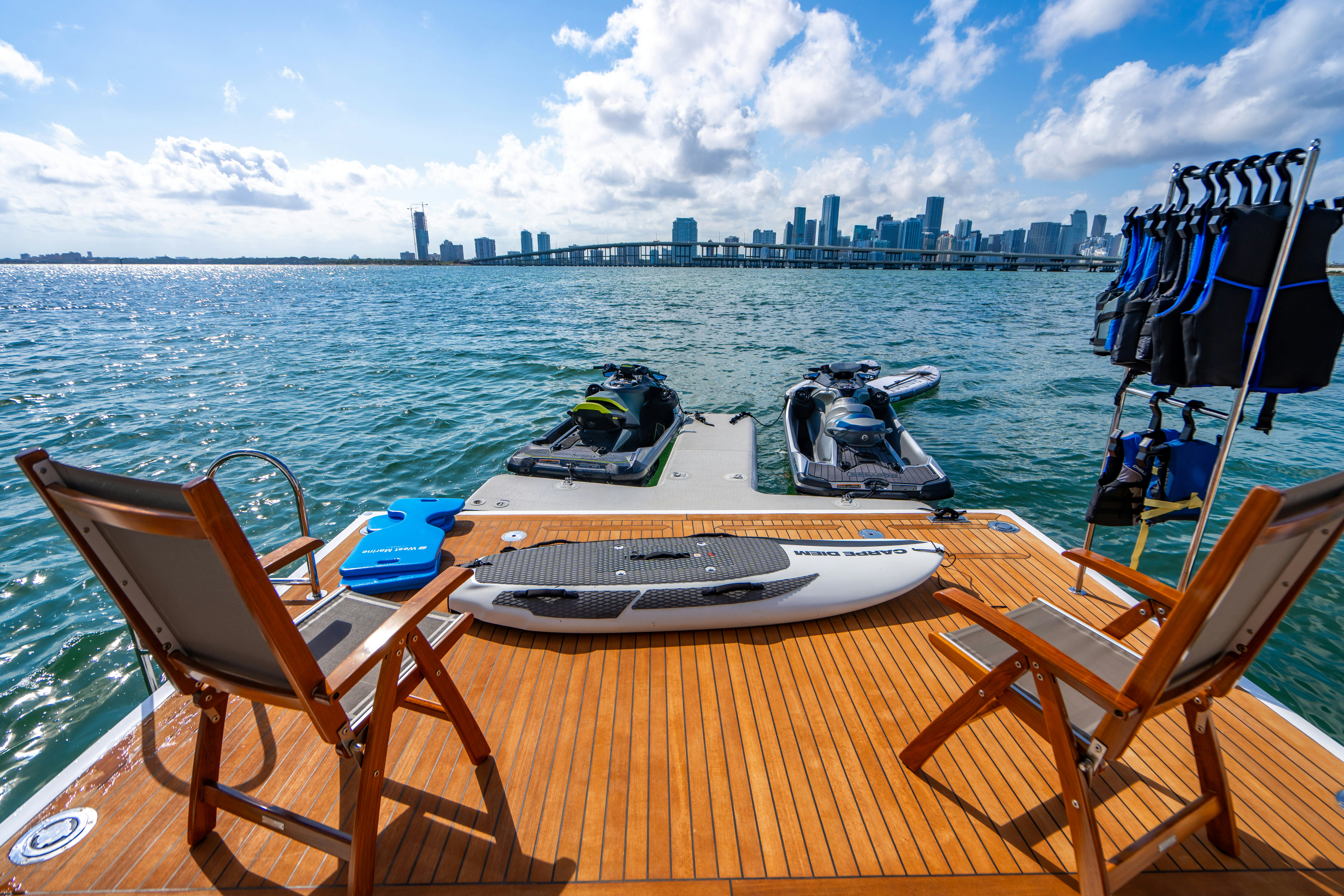 a deck with a chair and boats on it by a body of water aboard CARPE DIEM Yacht for Charter