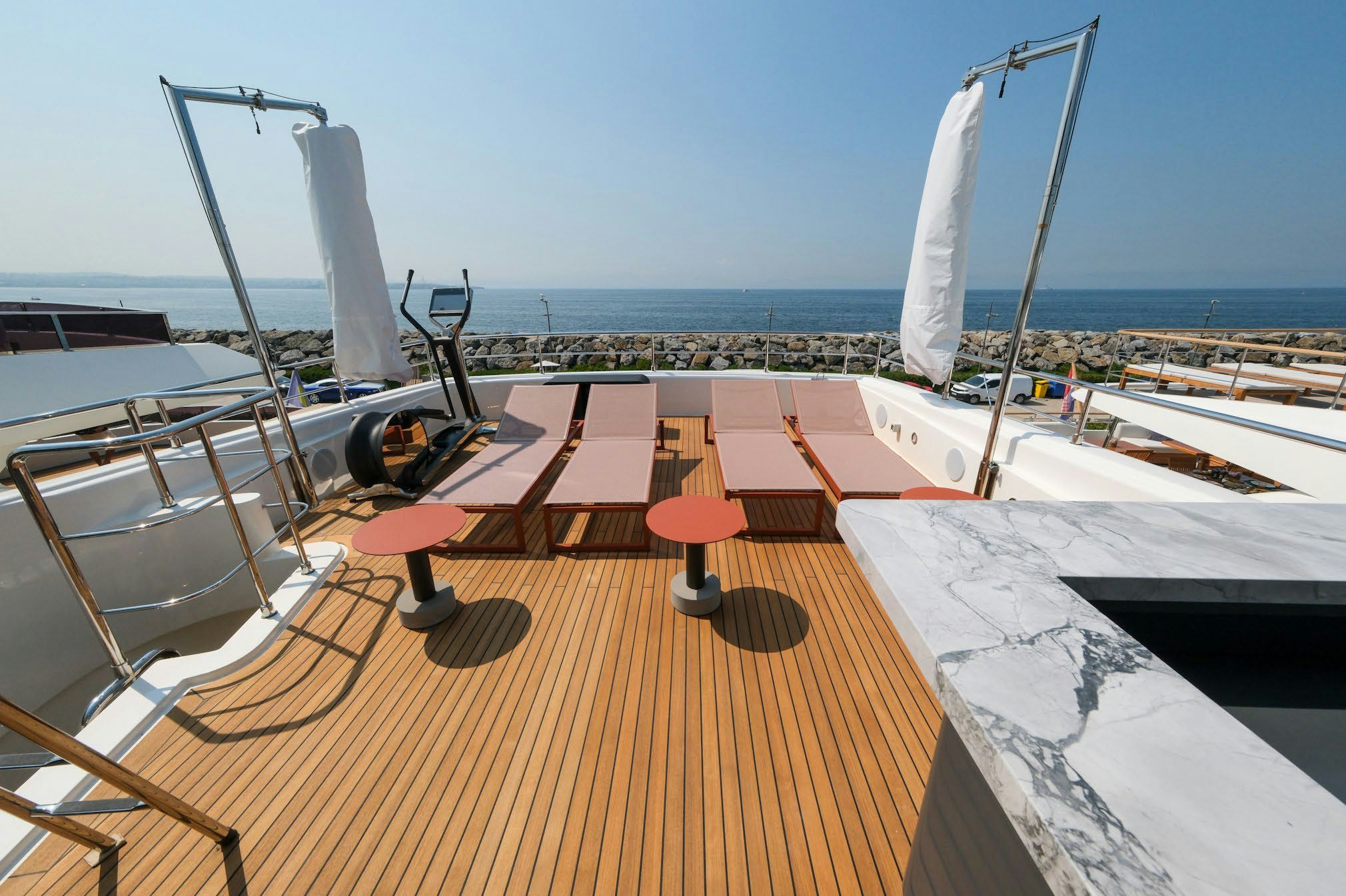 a deck with a boat and a large sailboat on it aboard AERO Yacht for Charter