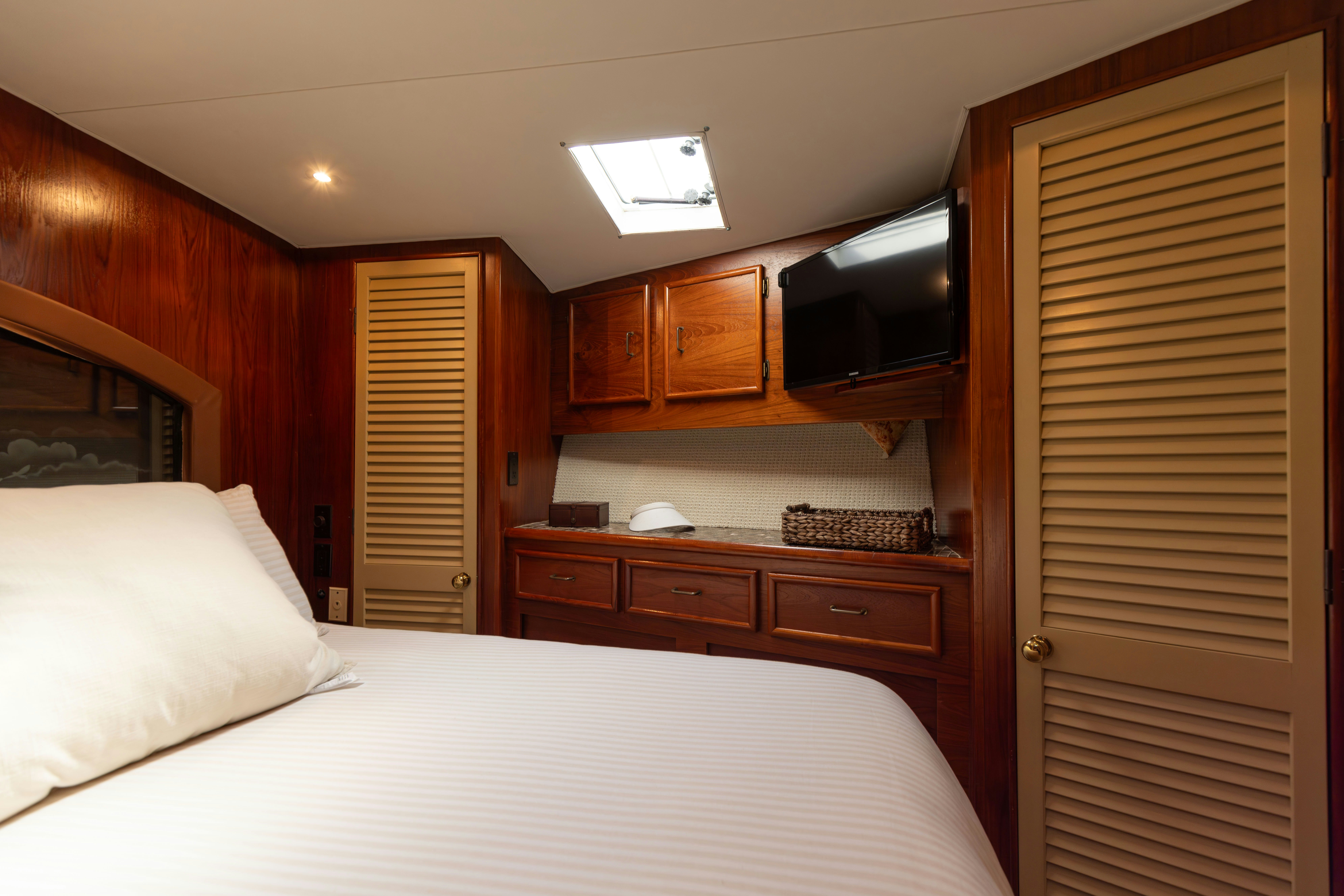 a bedroom with a bed and tv aboard LUCKY MARLIN Yacht for Sale