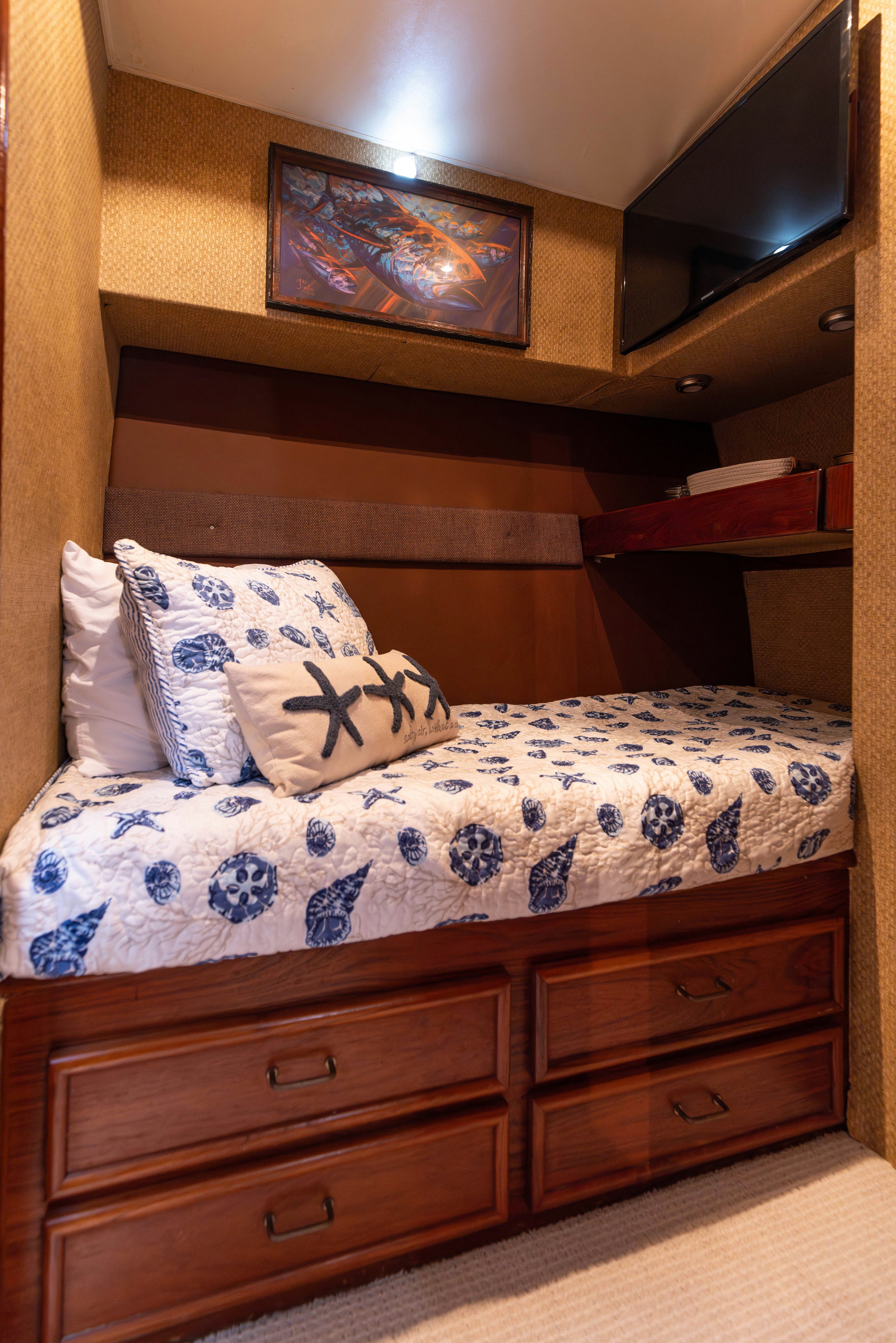 a bed with a blue and white blanket and pillows aboard LUCKY MARLIN Yacht for Sale