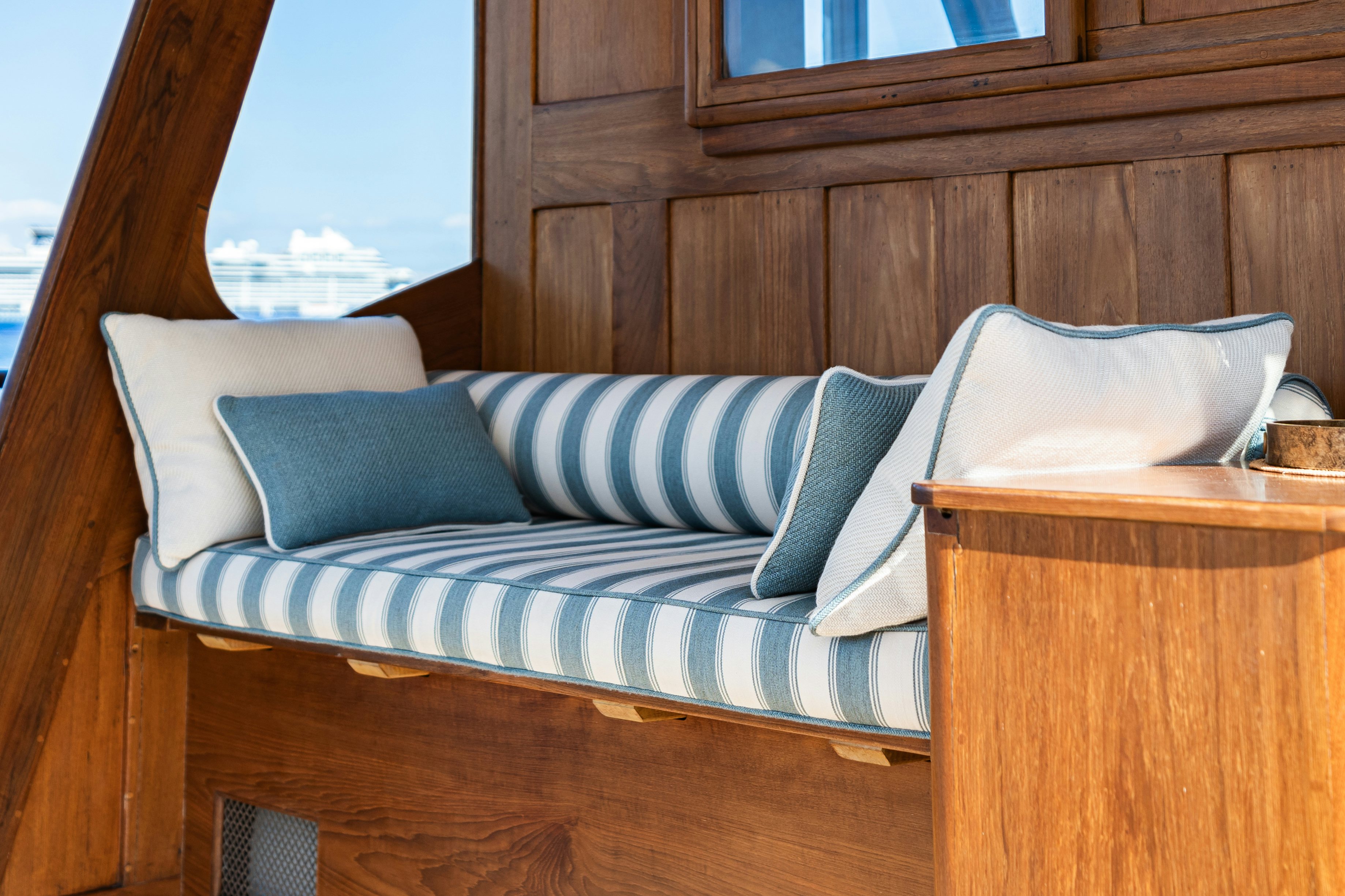a bed with a blue and white striped pillow and a wooden headboard aboard SILVER LASS Yacht for Sale