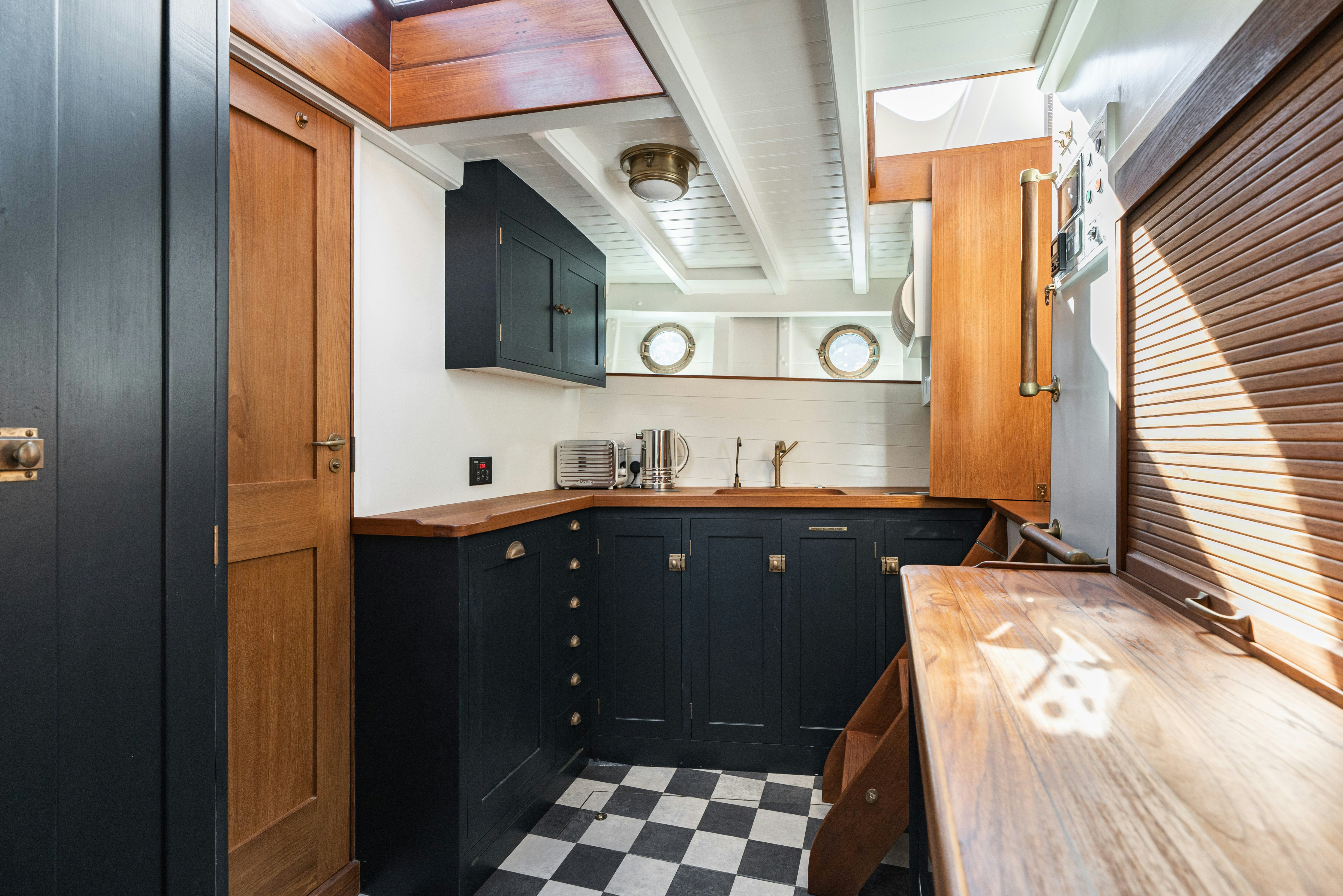 a kitchen with black cabinets aboard SILVER LASS Yacht for Sale