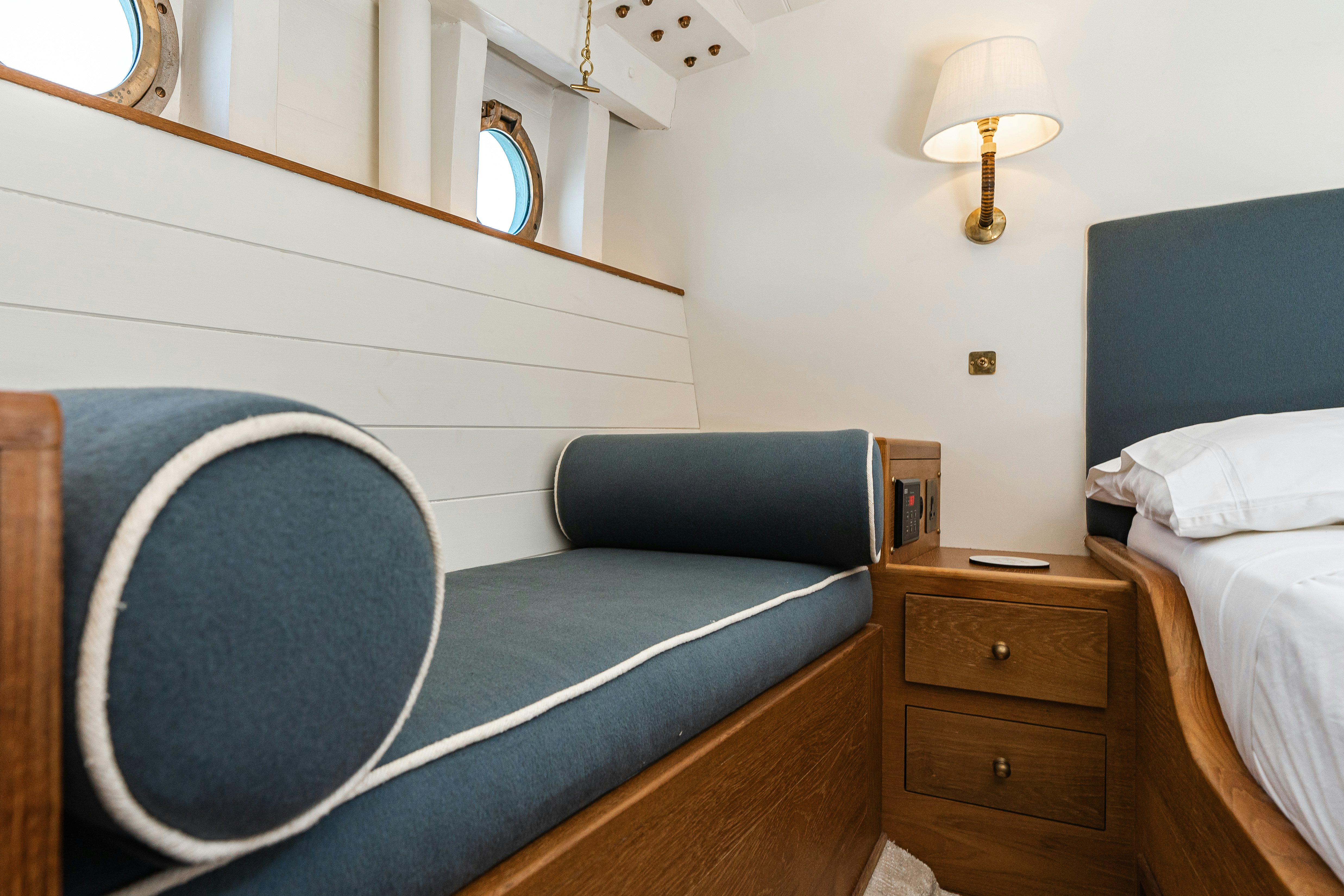 a bed with a blue bed spread aboard SILVER LASS Yacht for Sale