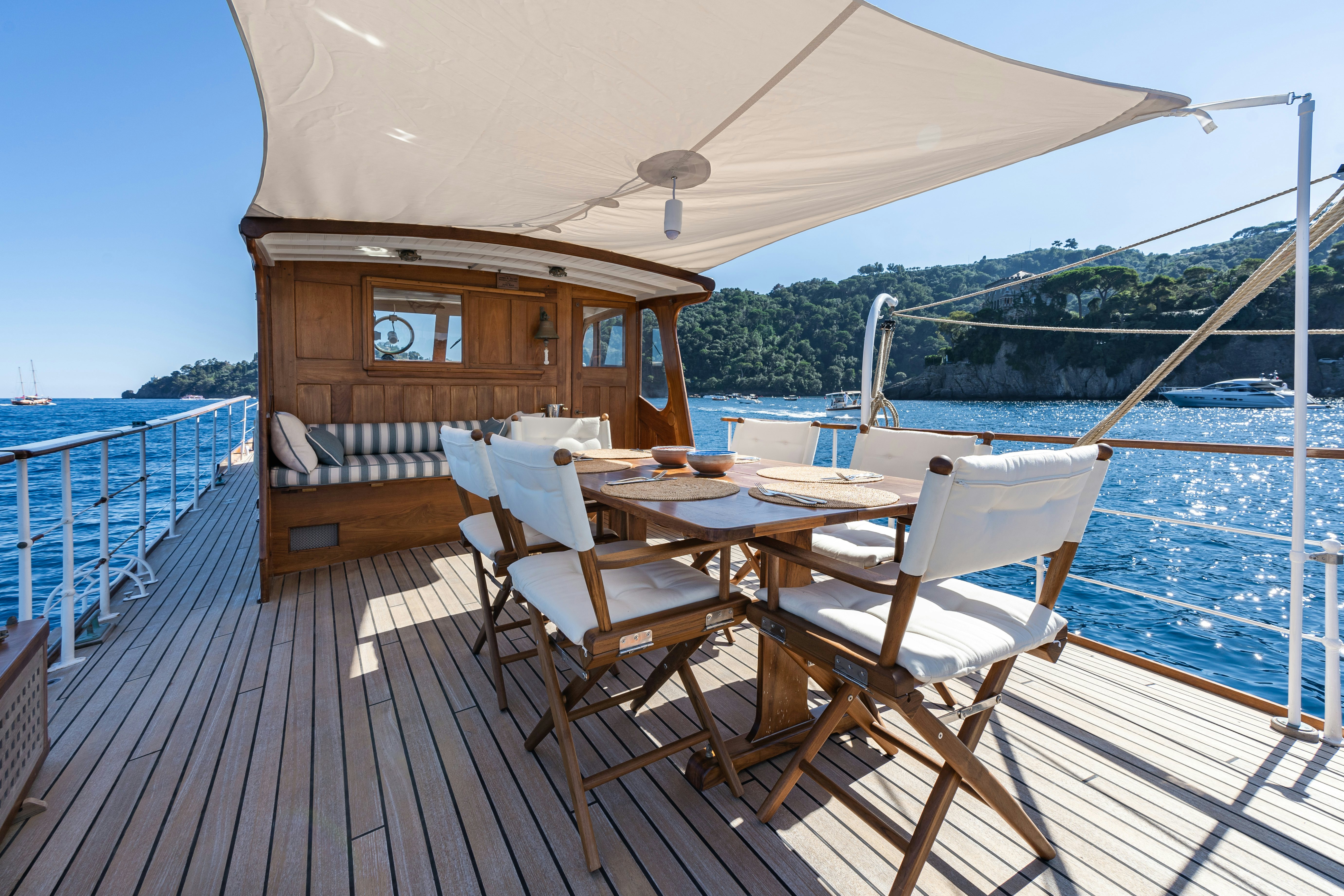 a deck with a table and chairs on it aboard SILVER LASS Yacht for Sale