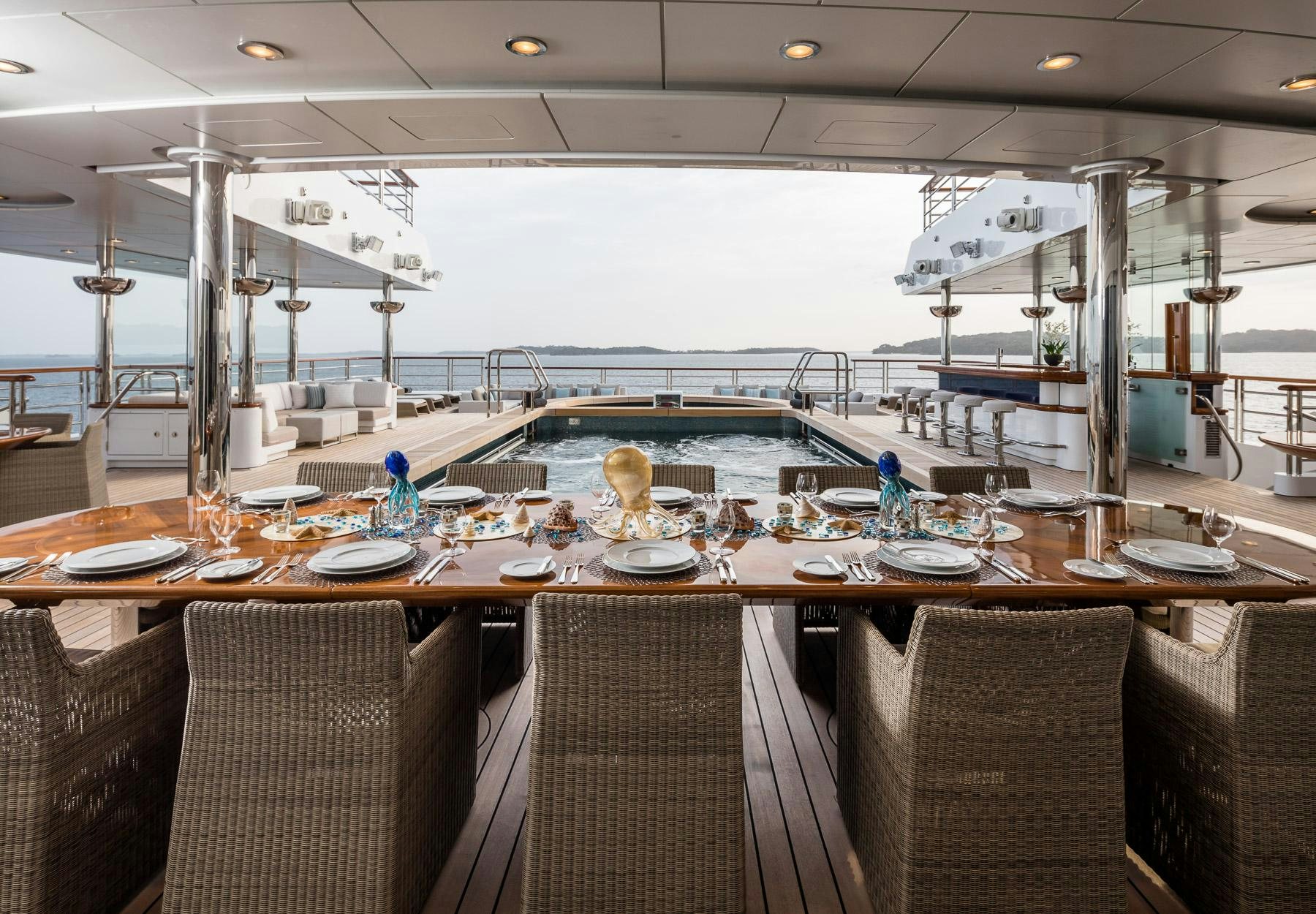 a large table with chairs and a large glass window aboard OCTOPUS Yacht for Charter