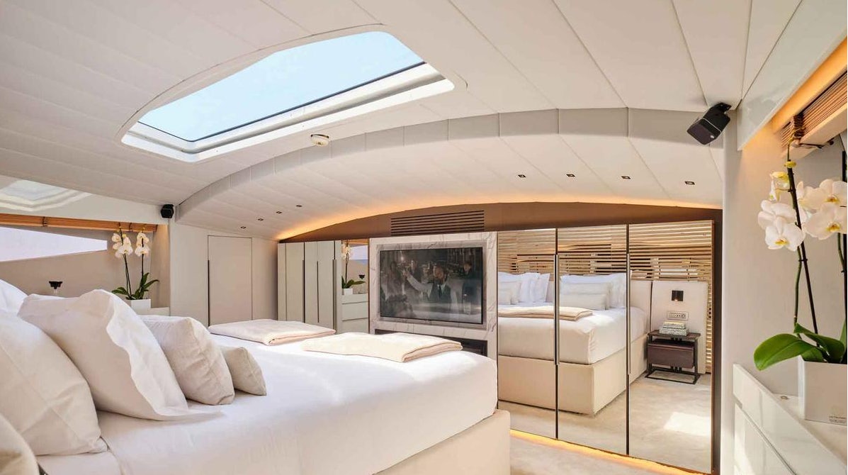 a room with a bed and a television aboard MAMMA MIA Yacht for Charter