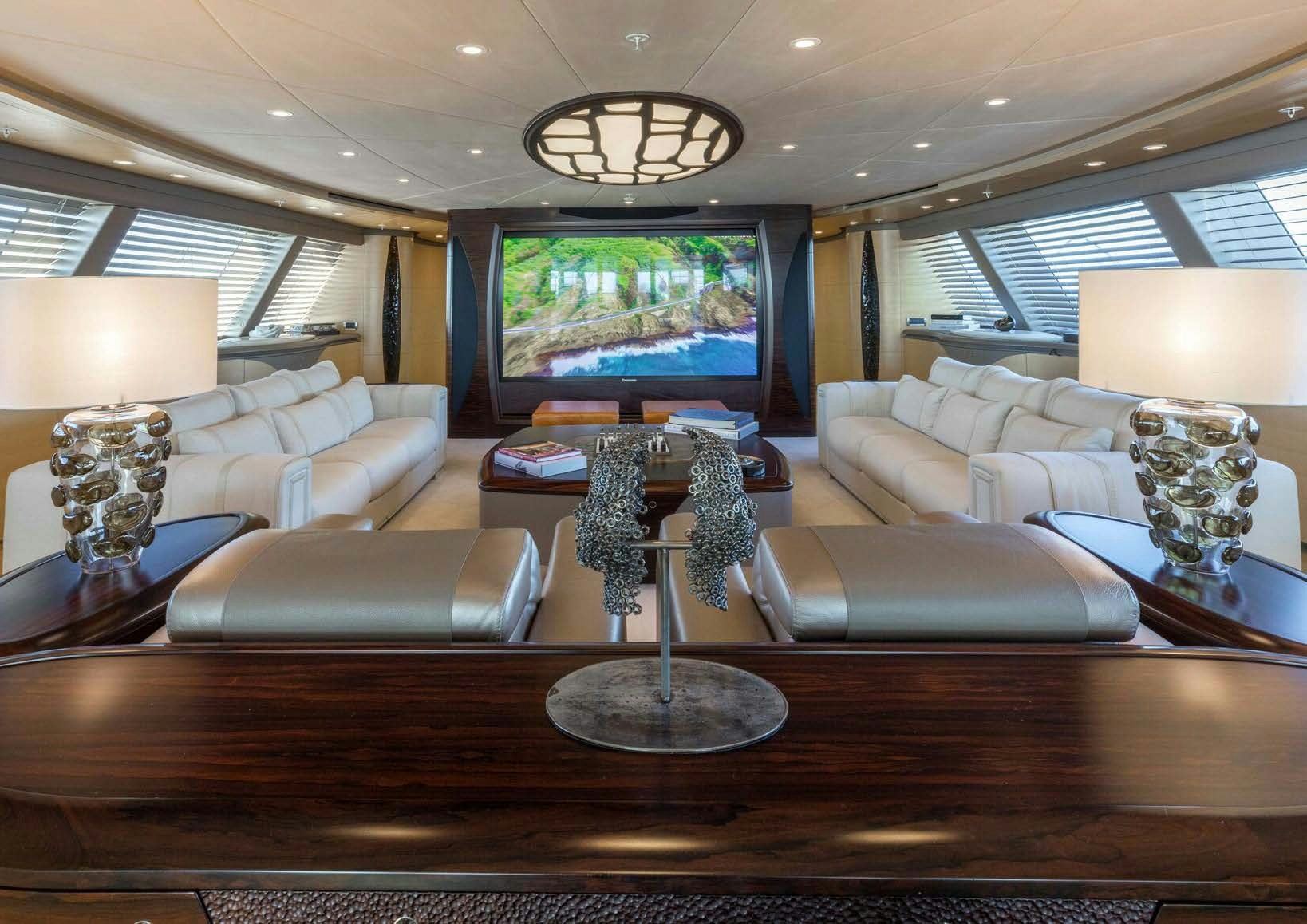 a living room with a large screen aboard SALVAJE Yacht for Sale