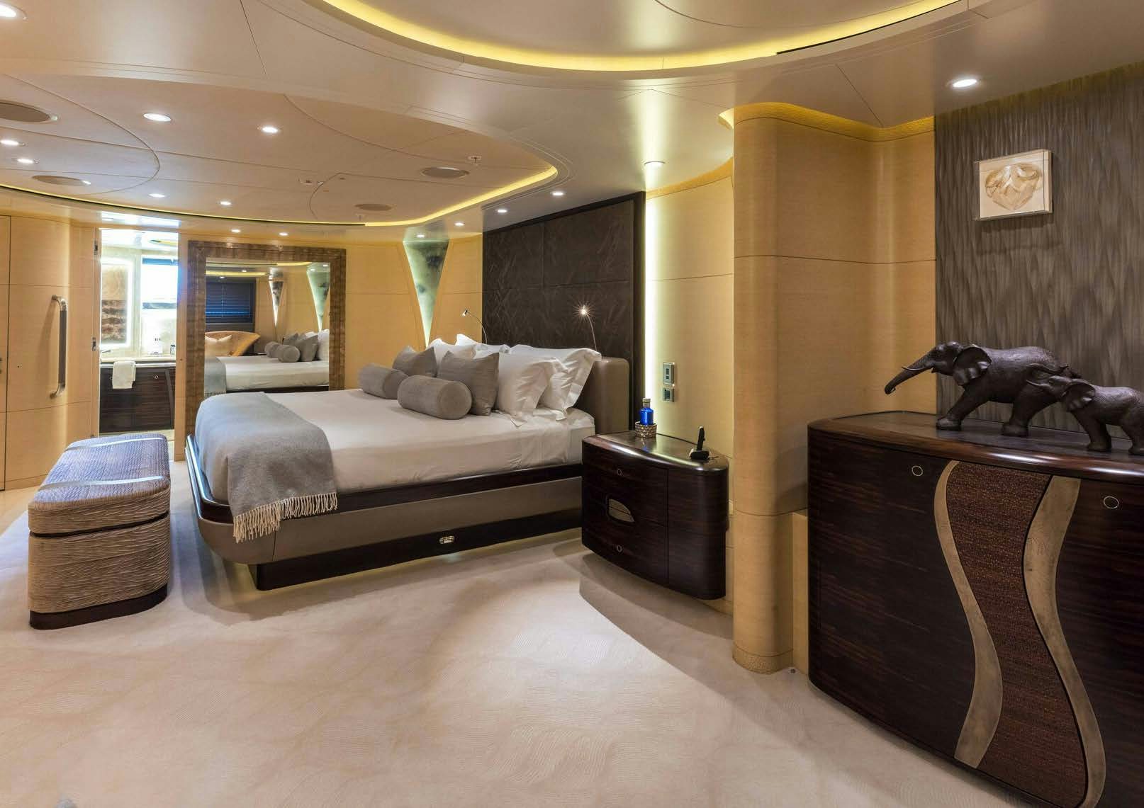 a bedroom with a bed and a dresser aboard SALVAJE Yacht for Sale