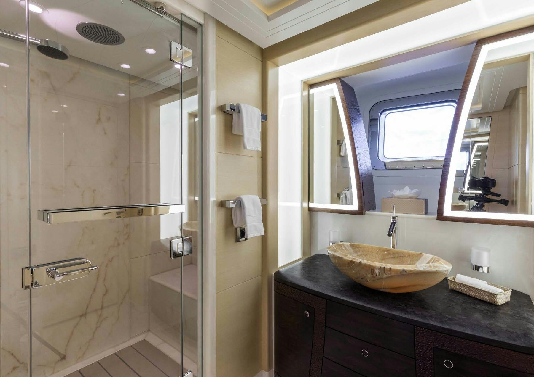 a bathroom with a glass shower aboard SALVAJE Yacht for Sale