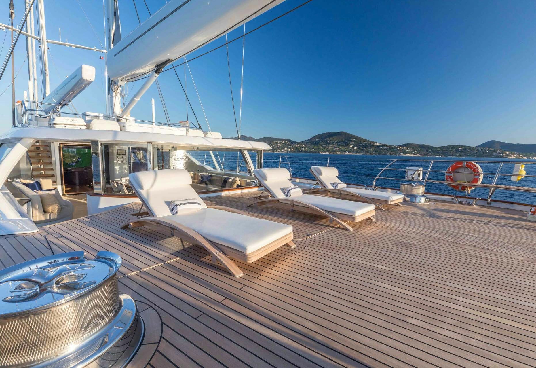 a deck with a boat and a dock with a view of the water aboard SALVAJE Yacht for Sale