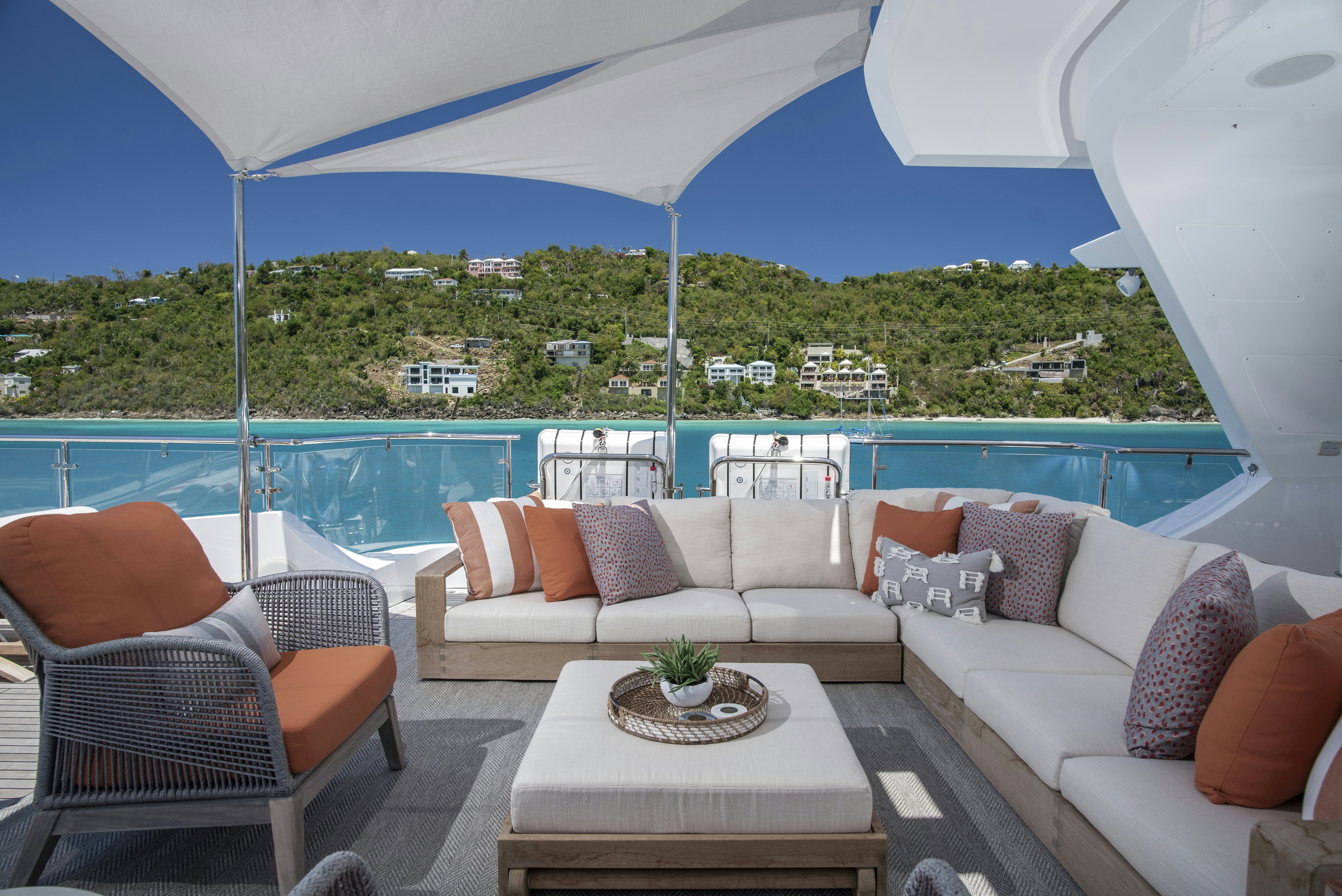 a living room with a large blue umbrella over a body of water aboard WABASH Yacht for Sale