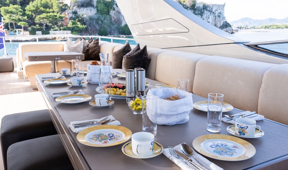 a table with plates and glasses on it aboard THE PALM Yacht for Charter