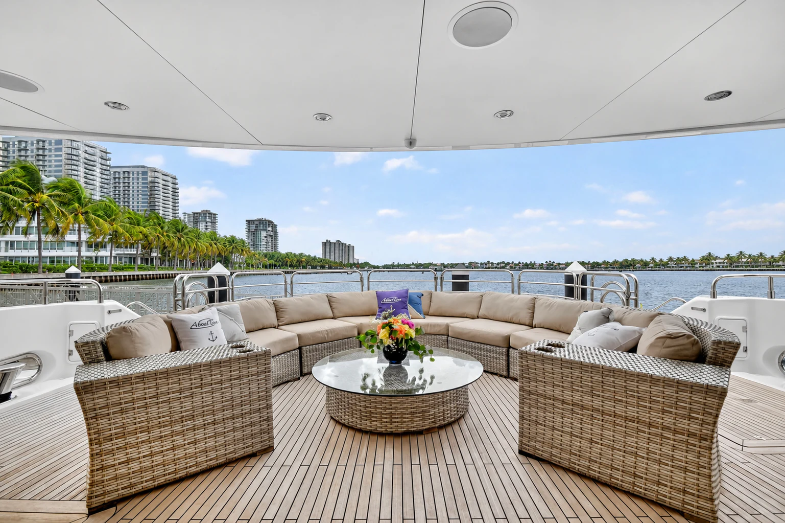a couch and a table on a balcony overlooking a beach aboard ABOUT TIME Yacht for Sale