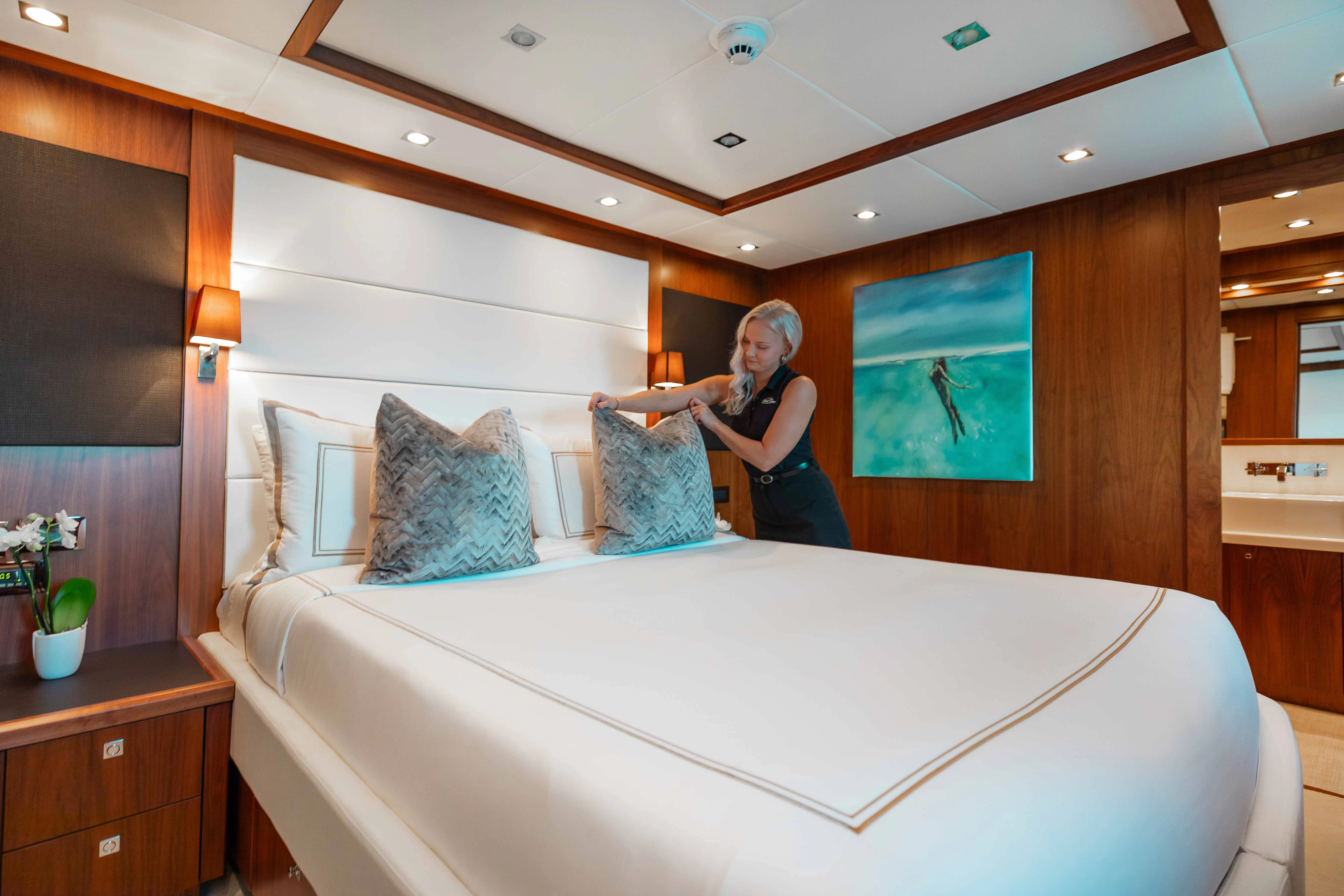 a person standing next to a bed aboard ABOUT TIME Yacht for Sale