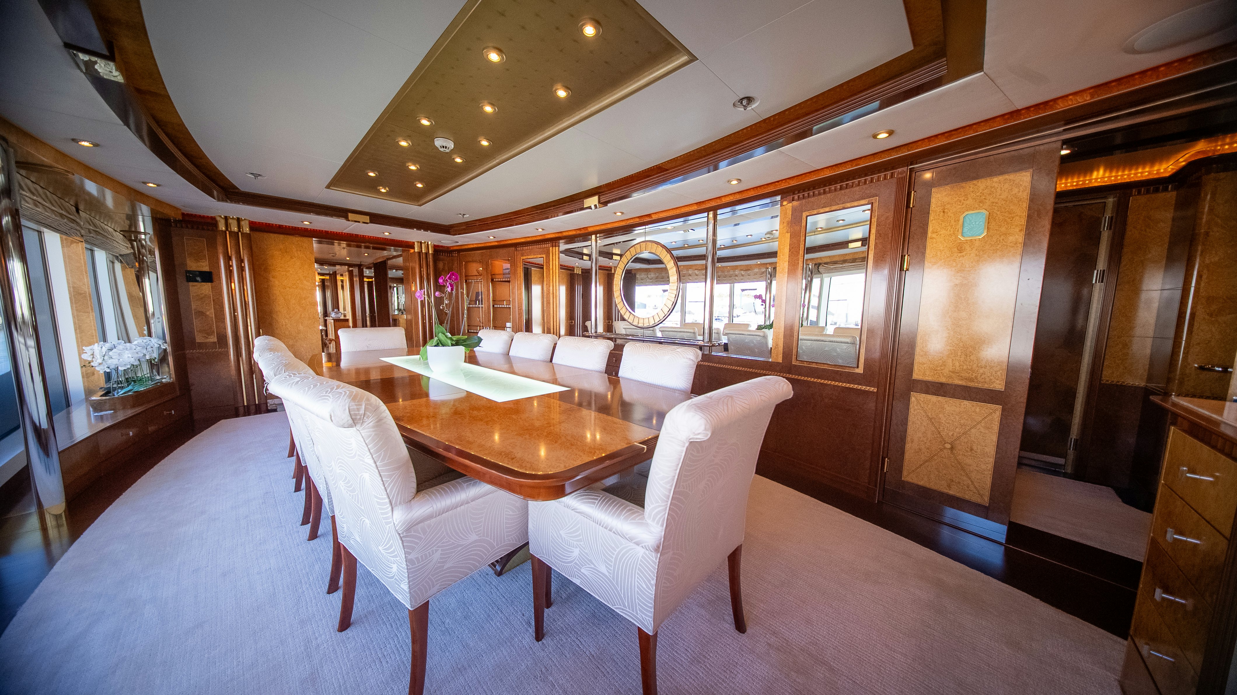 a room with a table chairs and a large window aboard LUDZIE Yacht for Charter
