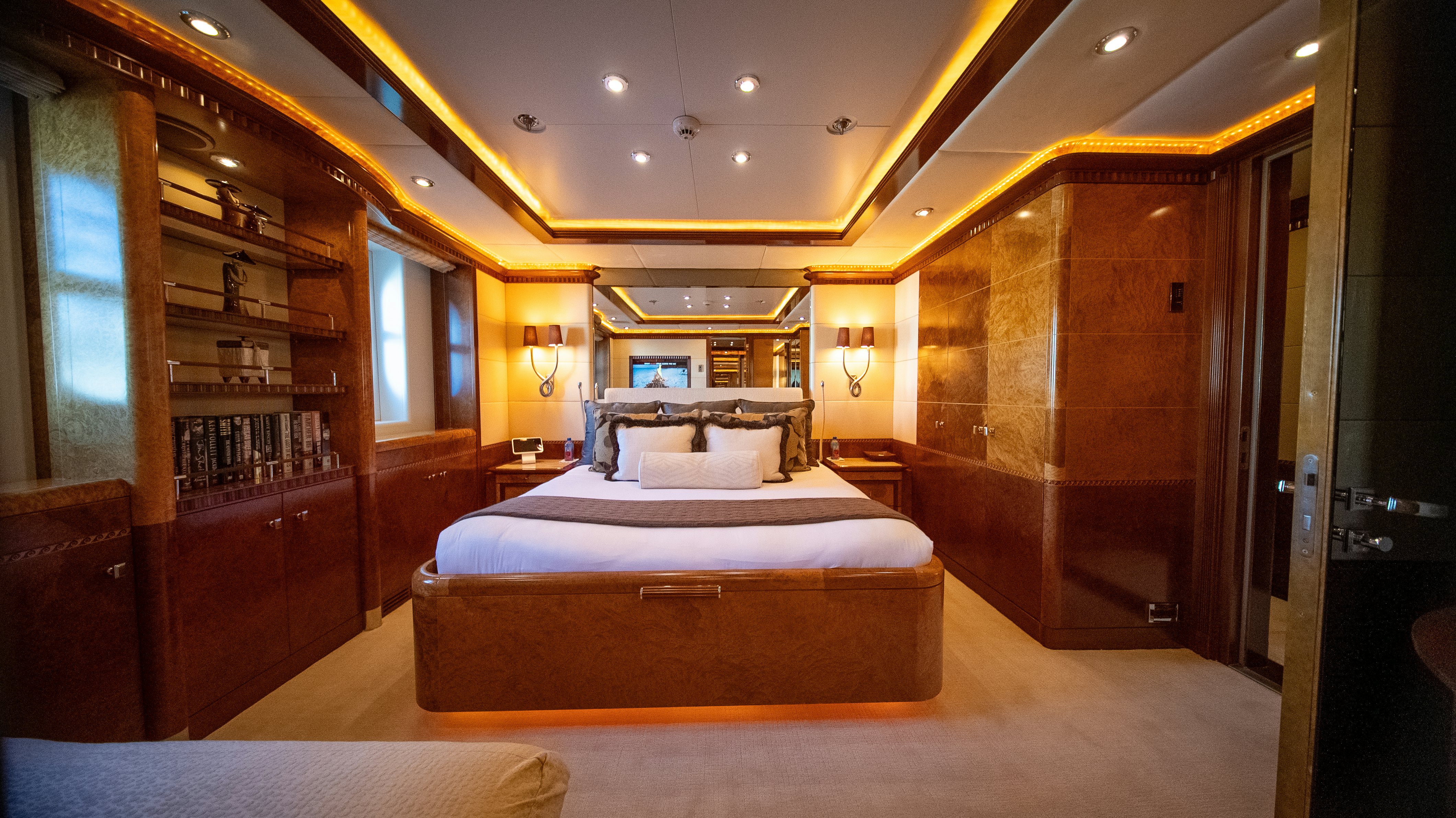 a room with a bed and a bookcase aboard LUDZIE Yacht for Charter