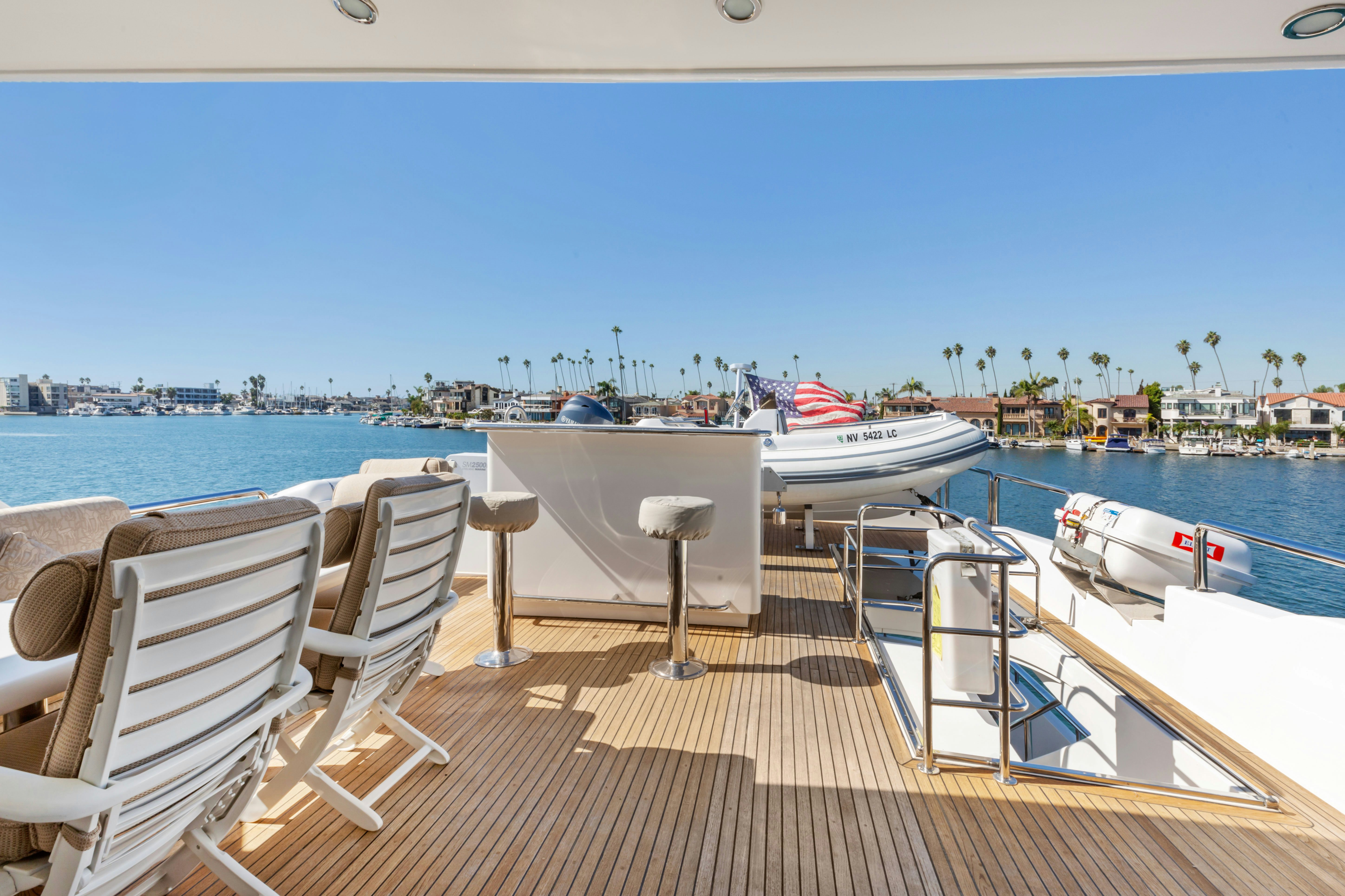 a deck with chairs and boats on it aboard REVERIE Yacht for Sale