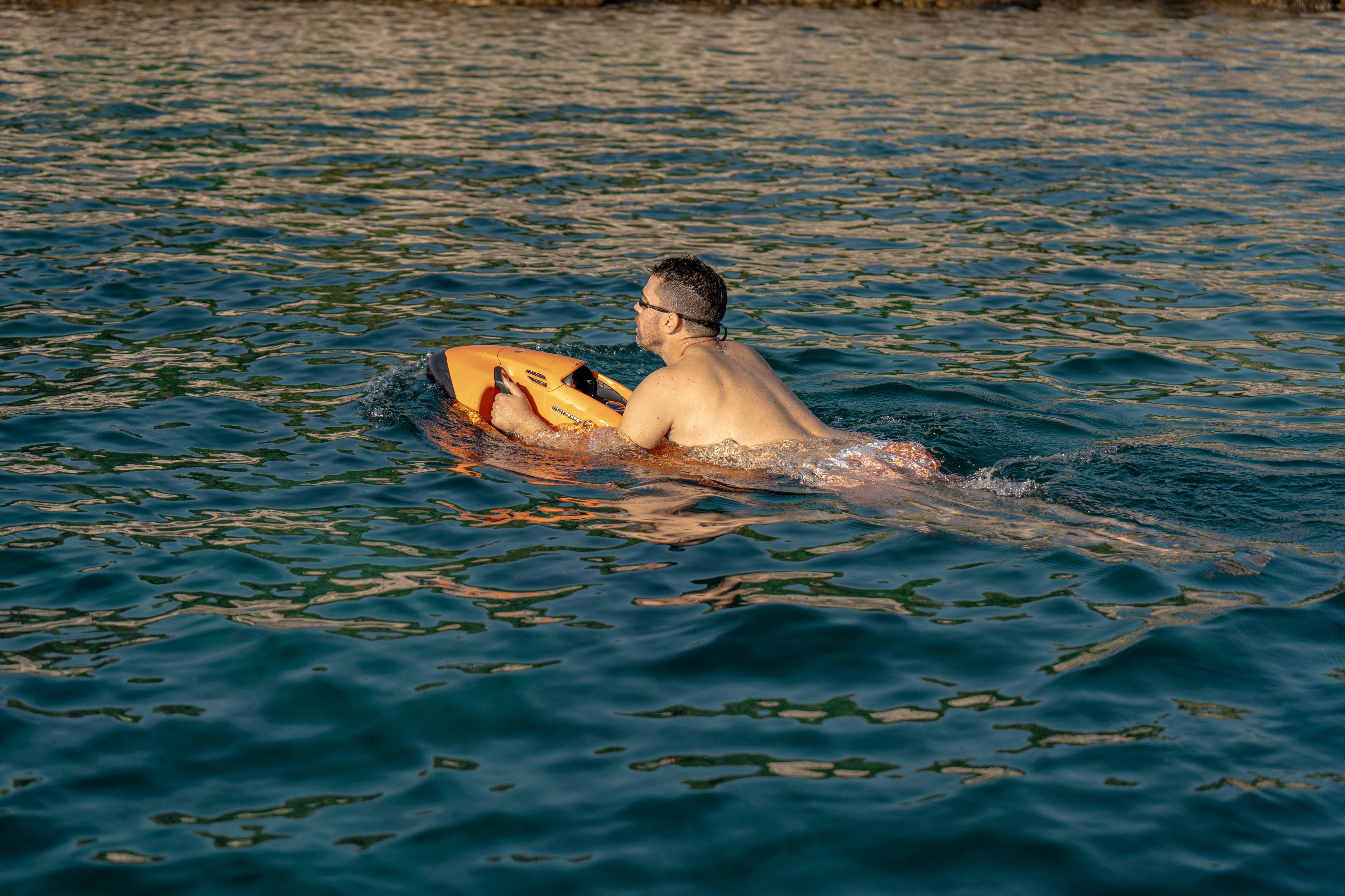 a man lying on a surfboard in the water aboard SANTA CLARA Yacht for Charter