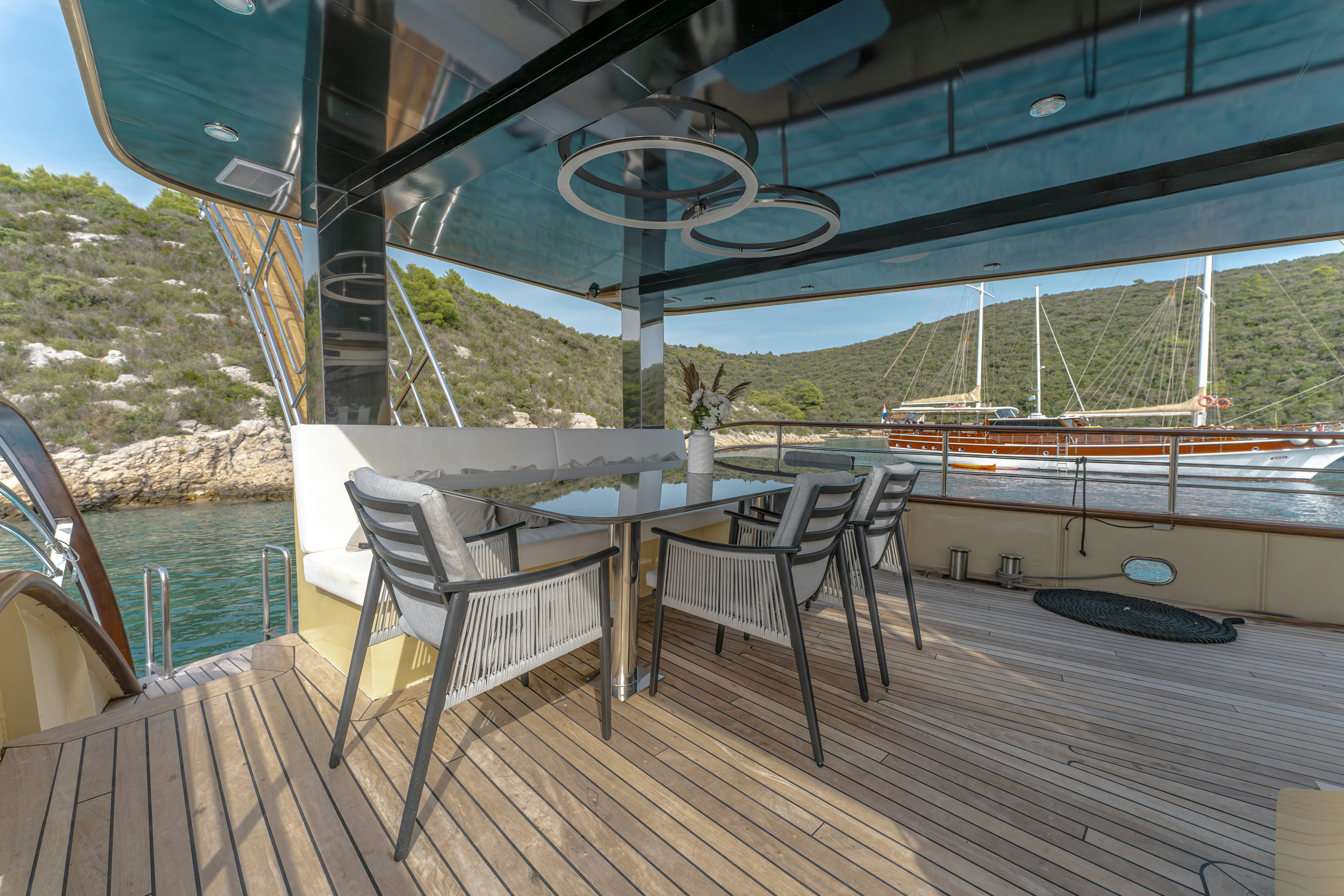 a deck with a table and chairs on it aboard SANTA CLARA Yacht for Charter