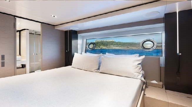 a bed with a large window aboard HAIAMI I Yacht for Charter