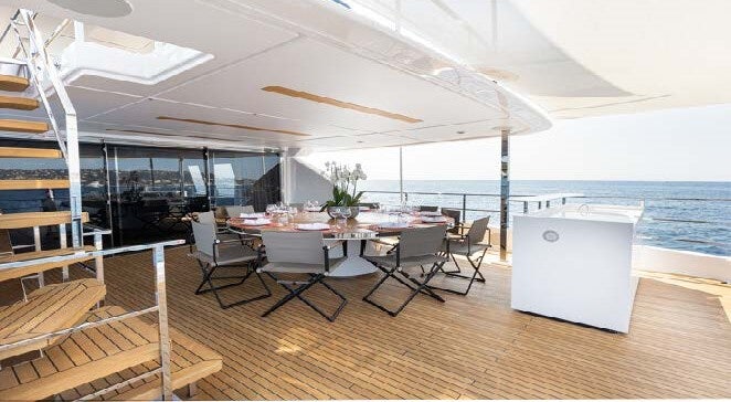 a room with a table chairs and a large window aboard HAIAMI I Yacht for Charter