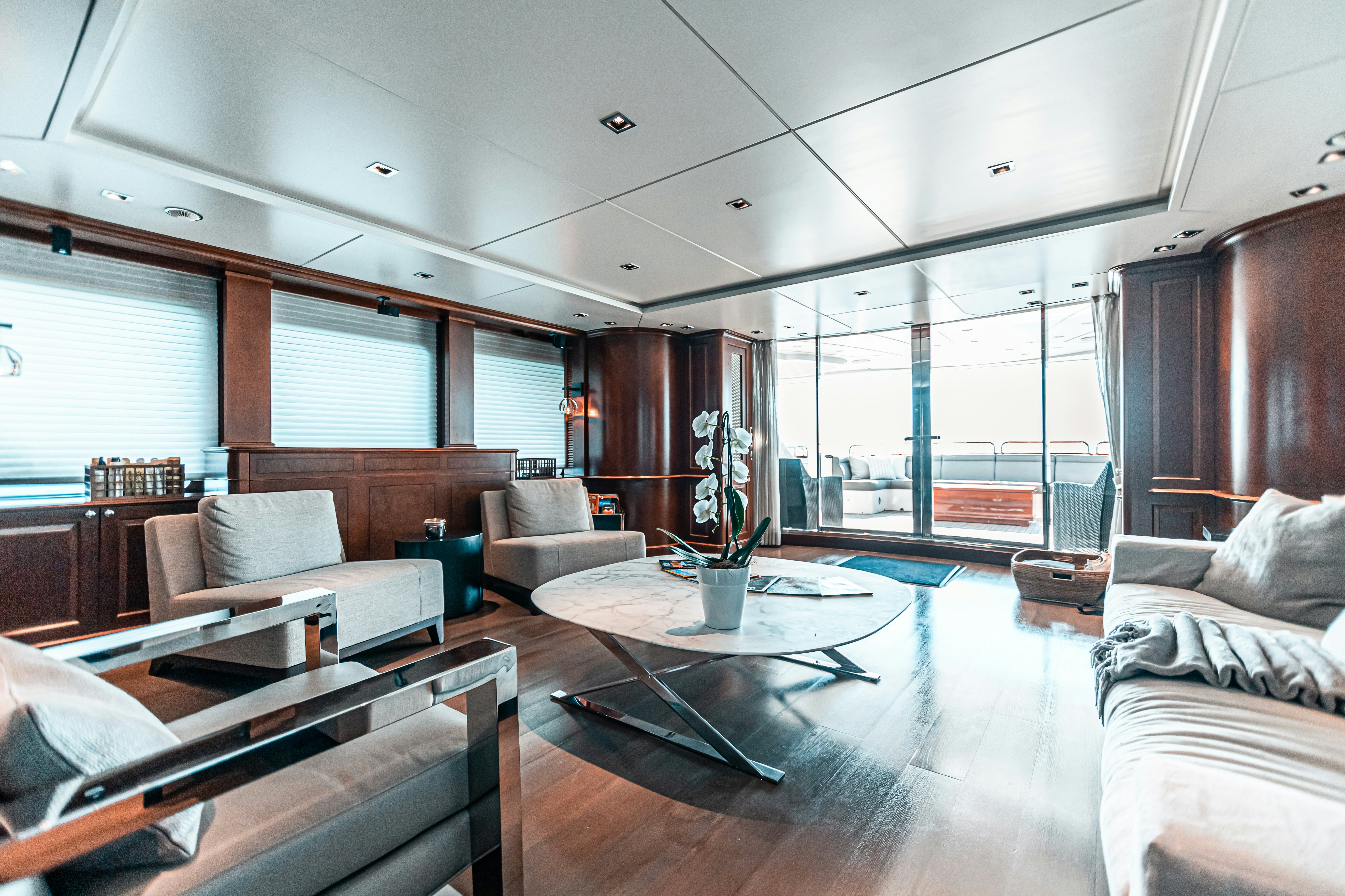 a living room with a glass coffee table and a large window aboard ARTHUR’S WAY Yacht for Charter