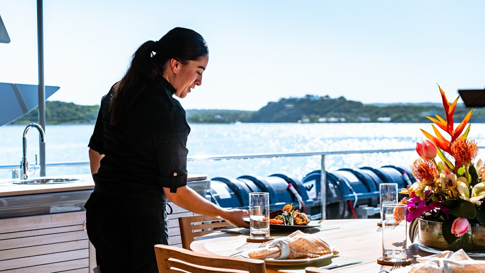 a couple of women standing at a table with food and drinks aboard NORMA JEAN Yacht for Charter