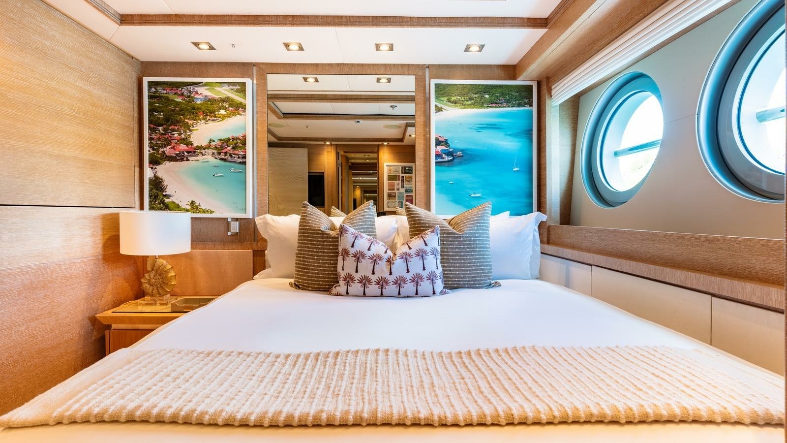 a bed with pillows and a large mirror in a room aboard NORMA JEAN Yacht for Charter