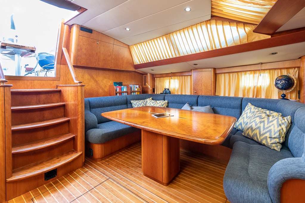 a living room with a wood table aboard JULIA Yacht for Sale