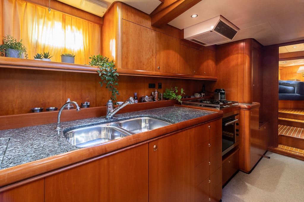 a kitchen with wooden cabinets aboard JULIA Yacht for Sale