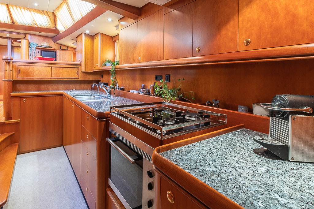 a kitchen with wooden cabinets aboard JULIA Yacht for Sale