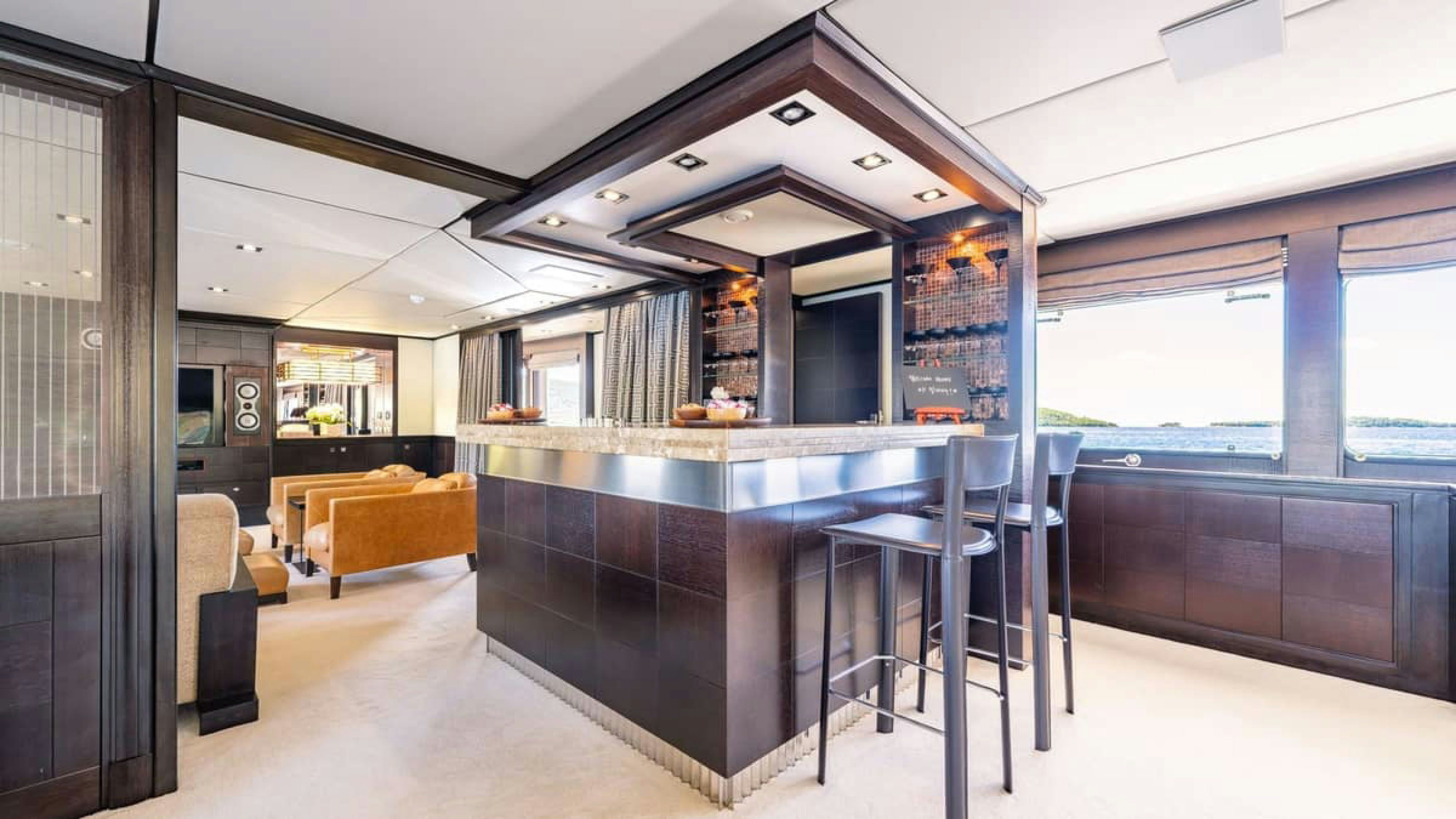 a large kitchen with a bar and bar stools aboard VICTORY Yacht for Charter