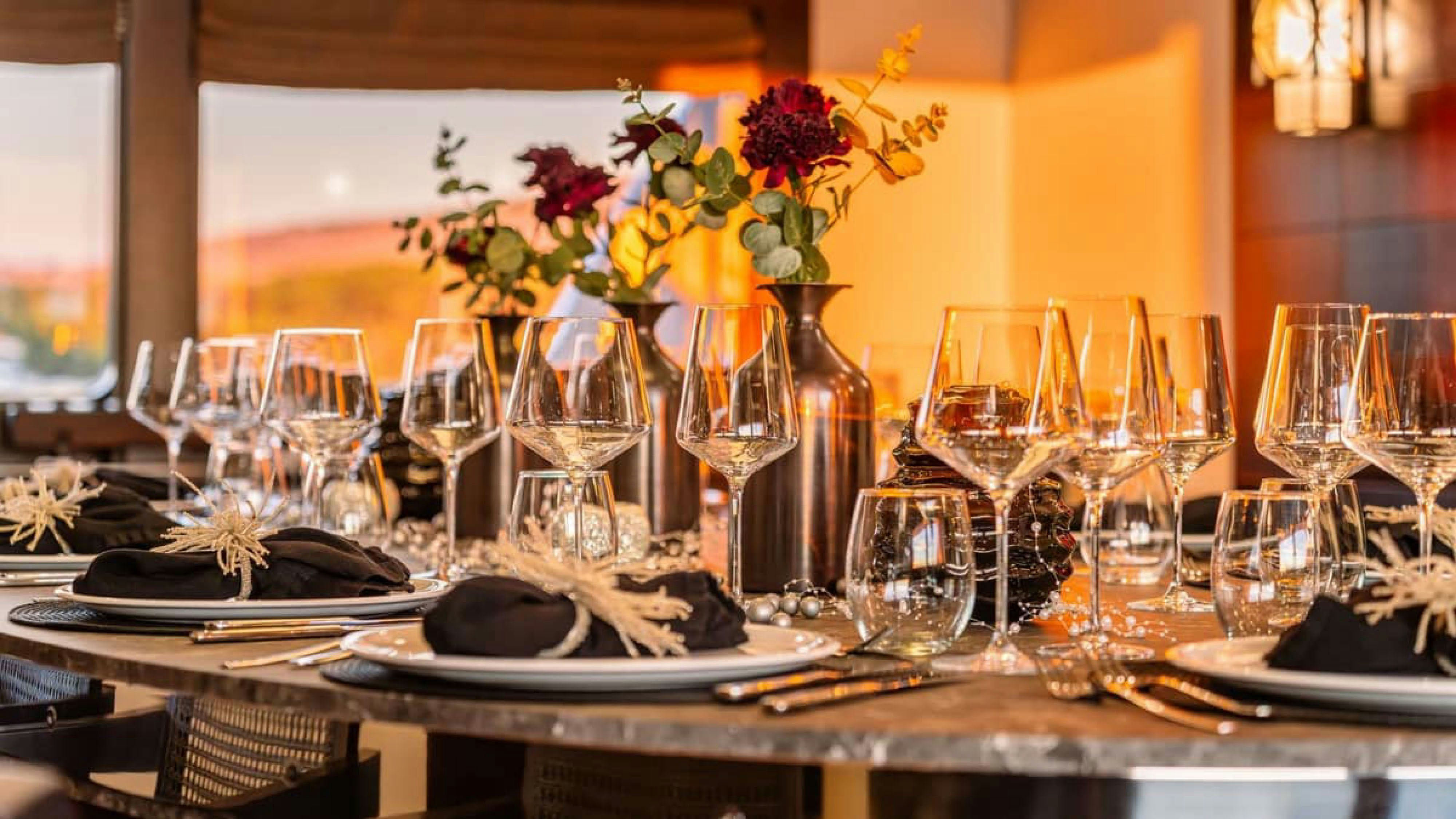 a table with wine glasses and plates aboard VICTORY Yacht for Charter