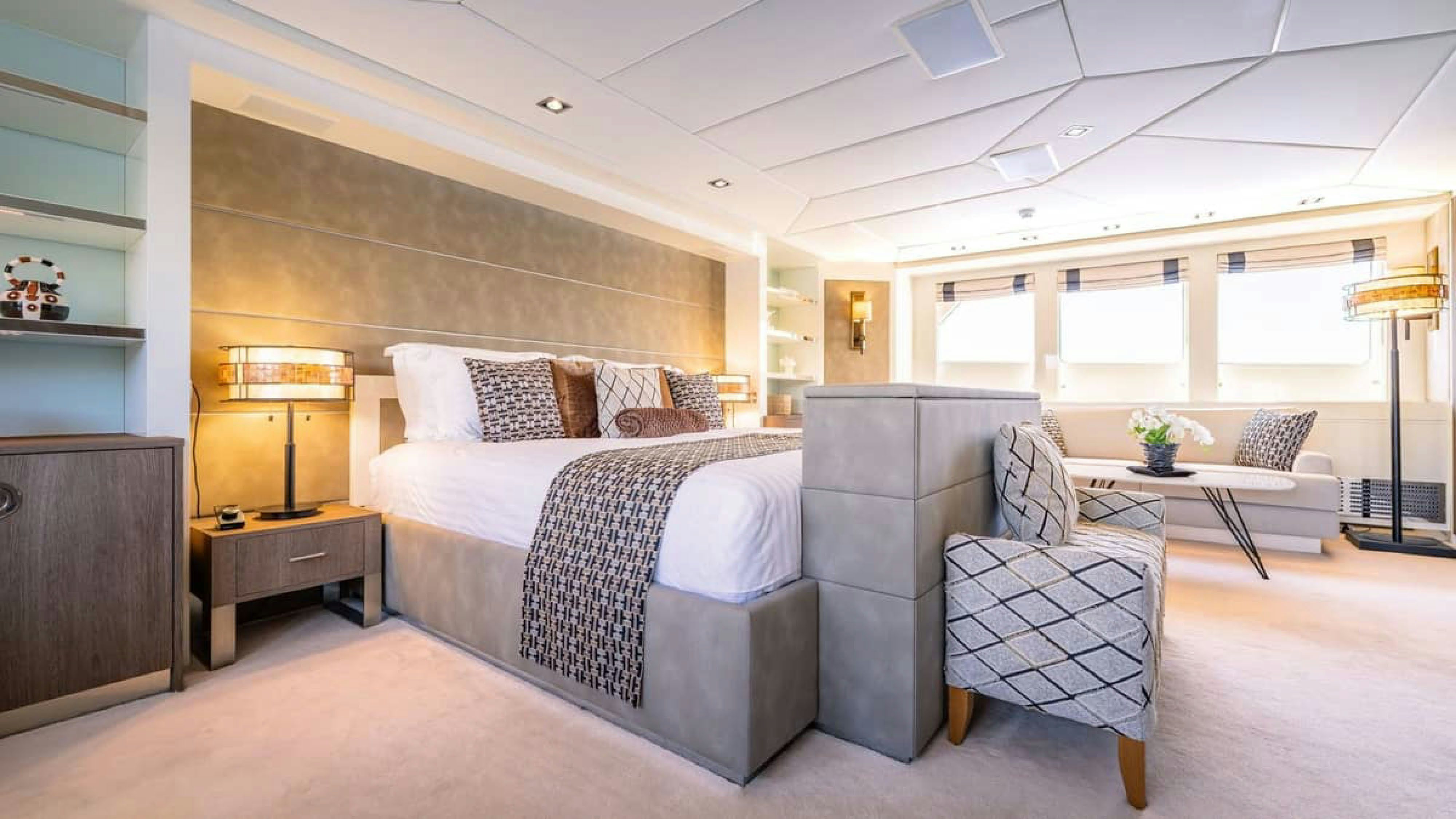 a bedroom with a bed and a table aboard VICTORY Yacht for Charter