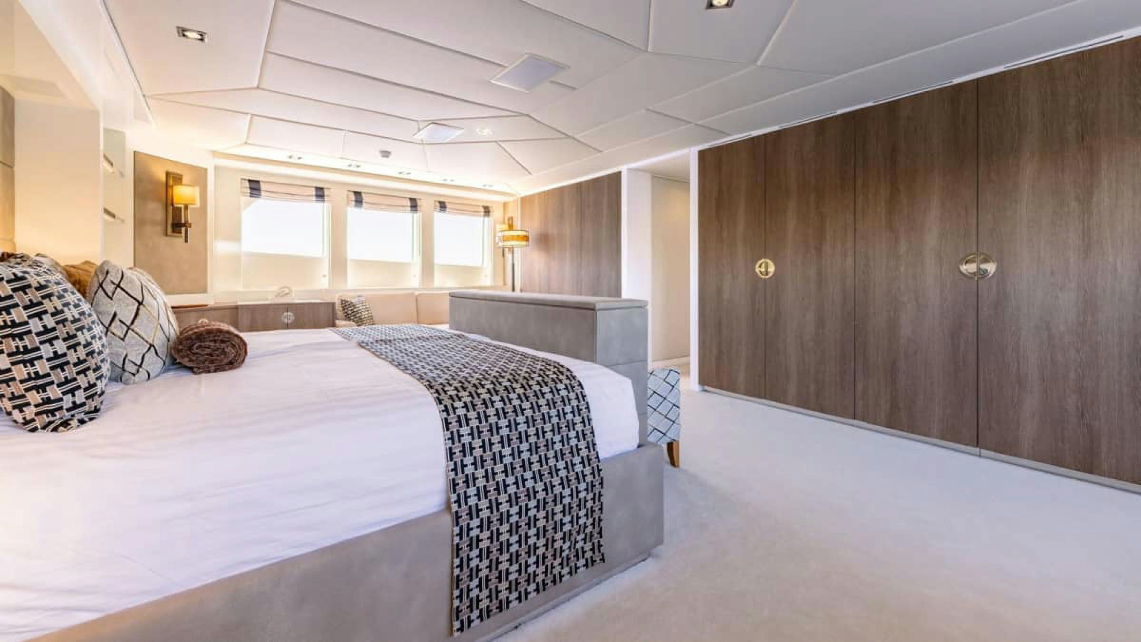 a room with a bed and a wood cabinet aboard VICTORY Yacht for Charter