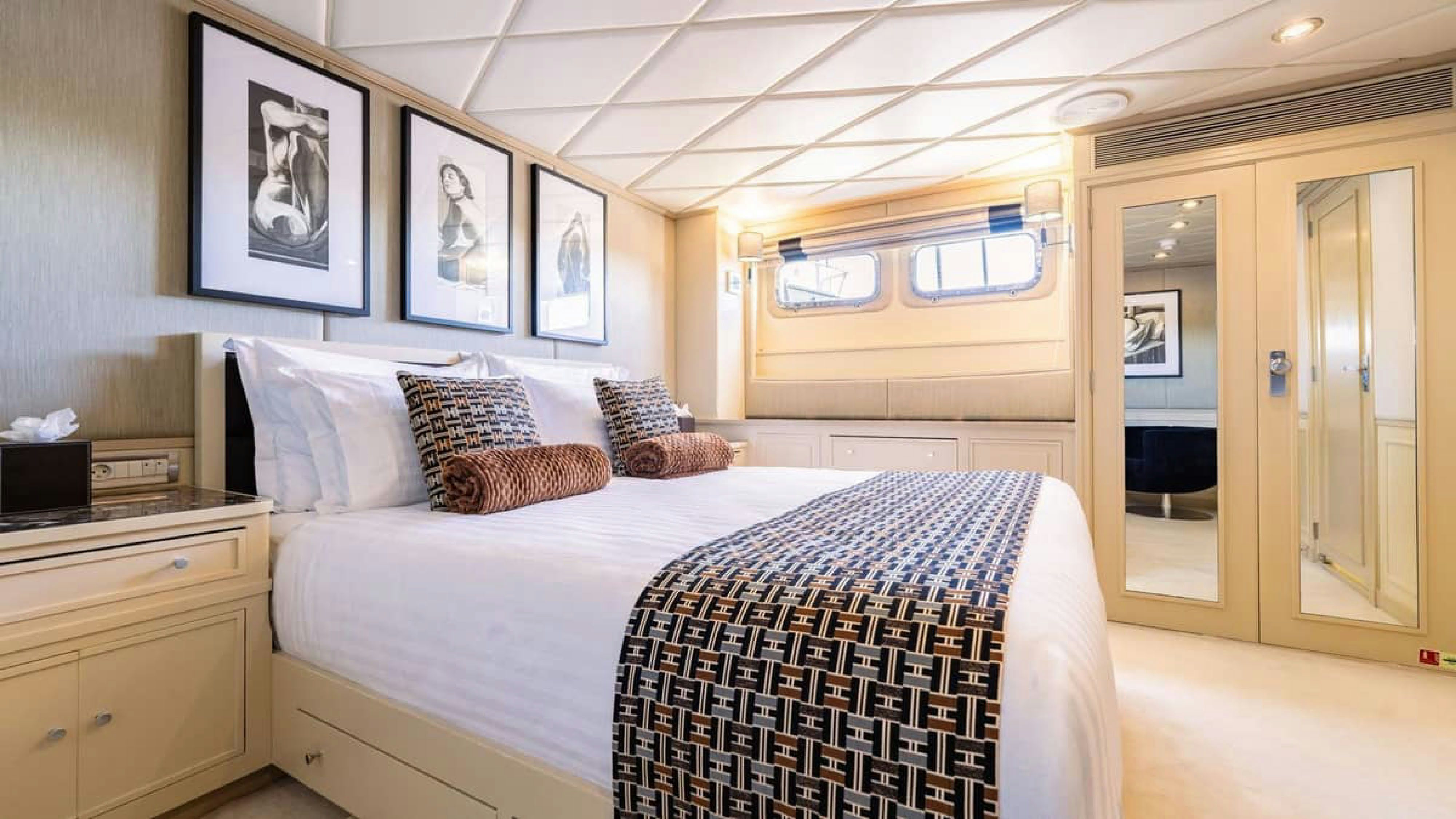 a bedroom with a bed and a desk aboard VICTORY Yacht for Charter