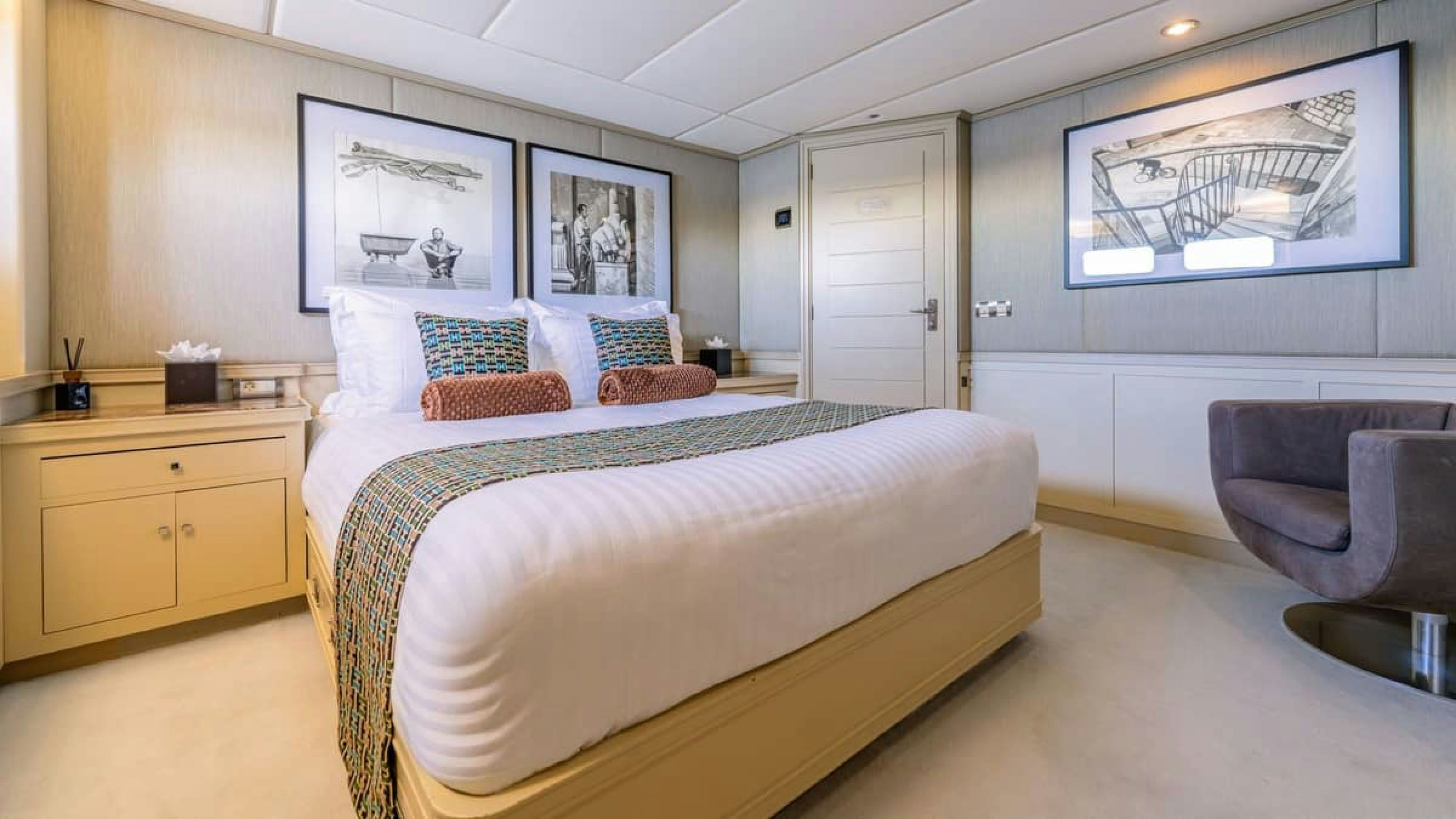 a bedroom with a bed and a chair aboard VICTORY Yacht for Charter