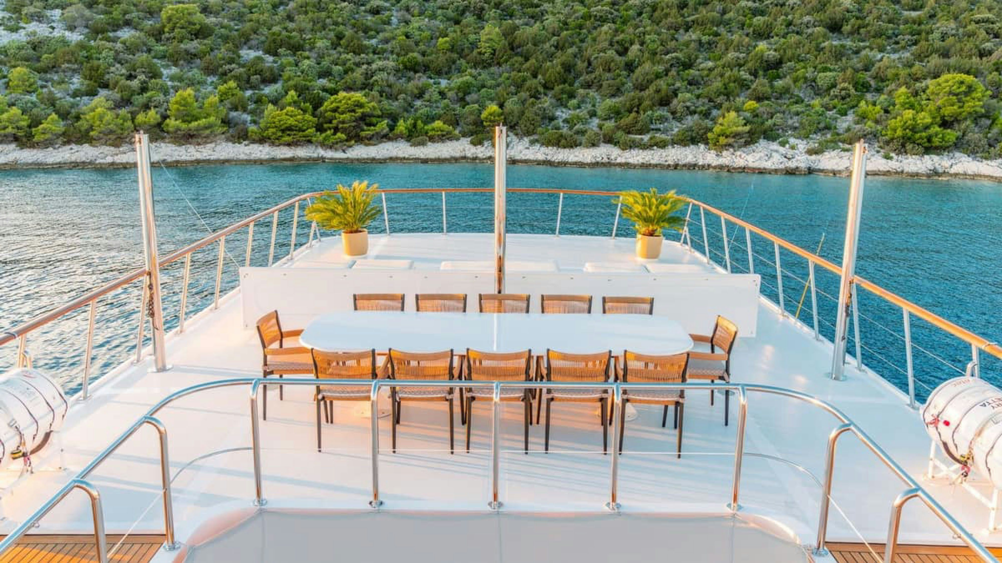 a deck with chairs and tables on it by a body of water aboard VICTORY Yacht for Charter