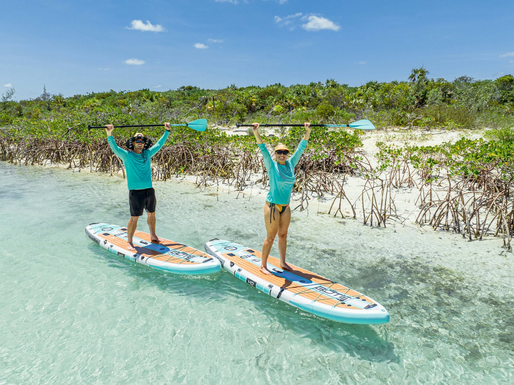 two people on surfboards in the water with Xelha in the background aboard VIVACE Yacht for Charter