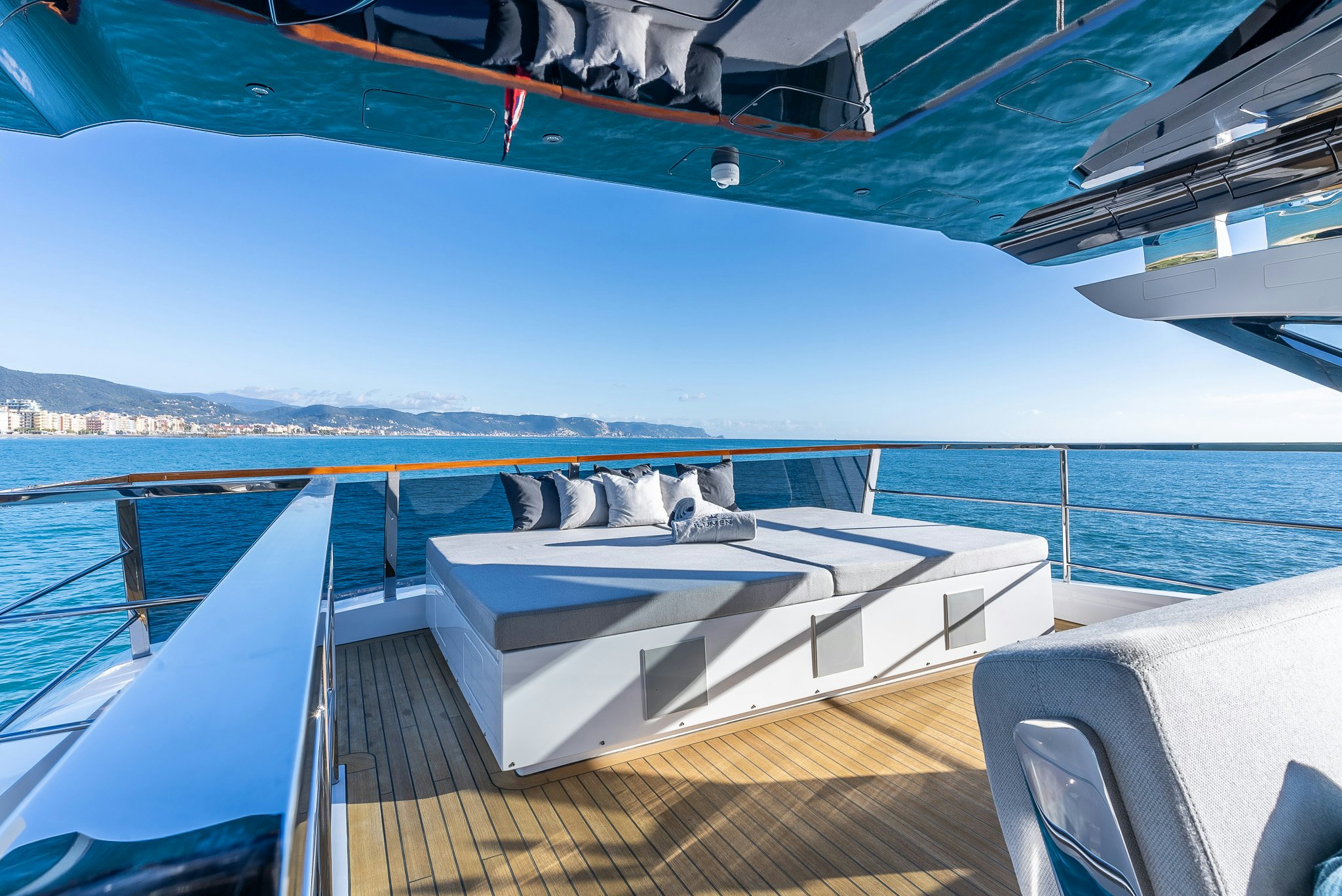 a deck with a large body of water and a boat on it aboard CADET V Yacht for Sale