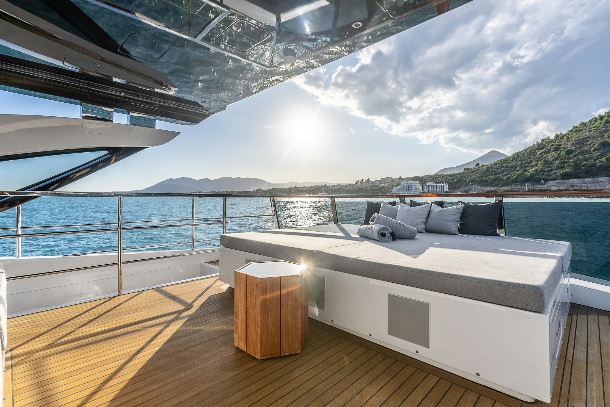 a deck with a view of the ocean and a large boat aboard CADET V Yacht for Sale