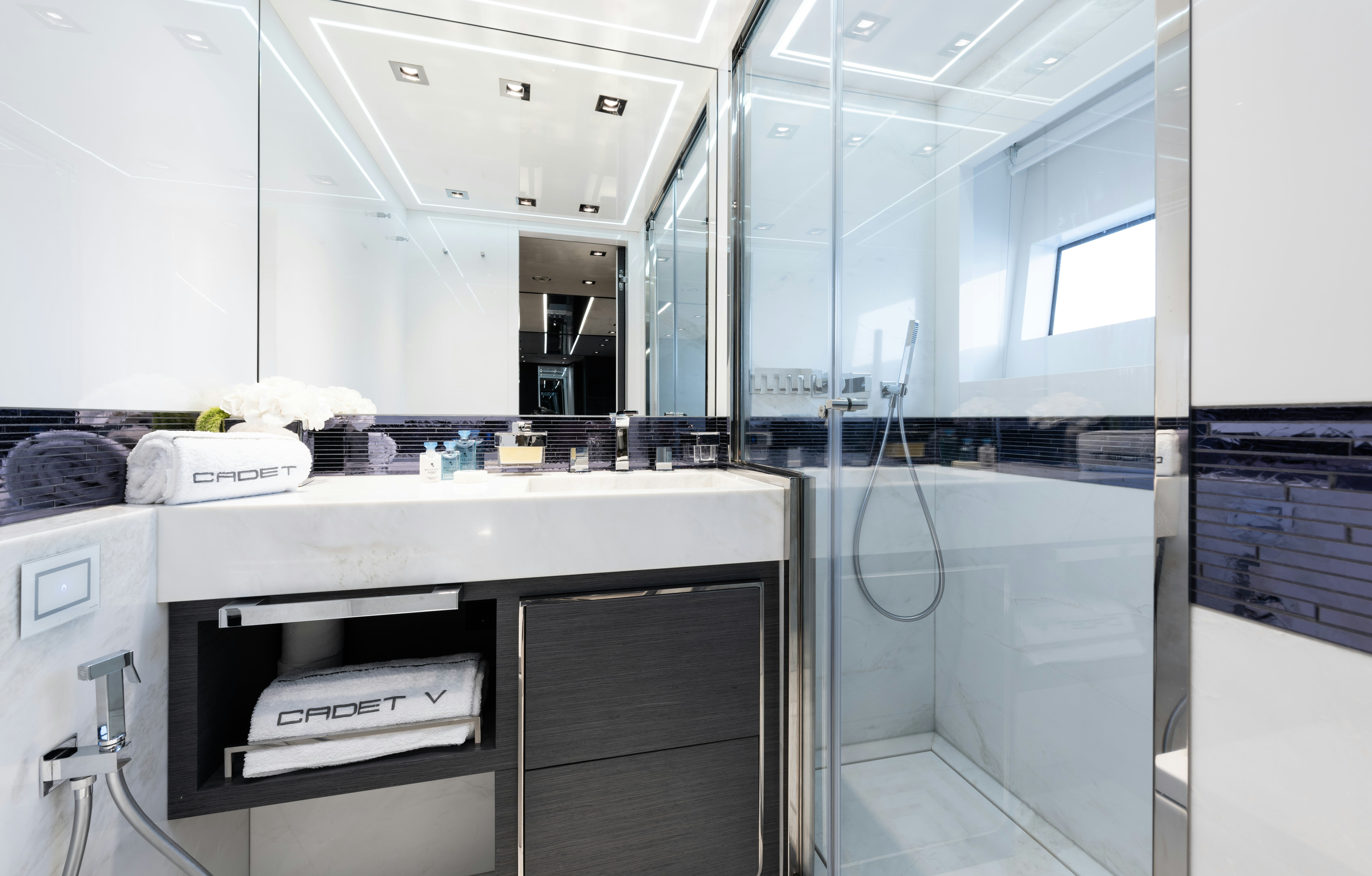 a room with a glass wall and a counter with a sink and cabinets aboard CADET V Yacht for Sale