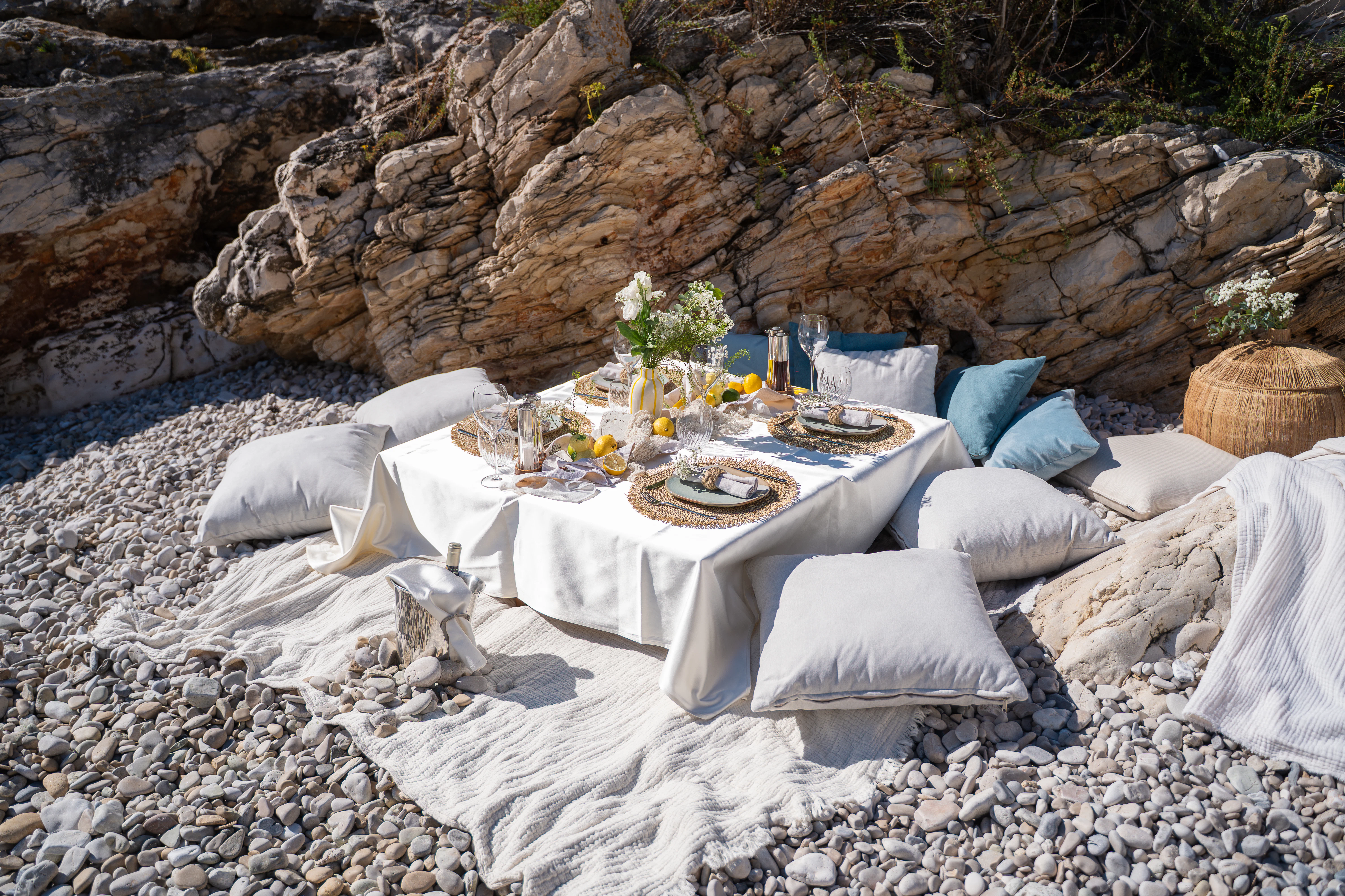 a table set with white cloths and white pillows aboard RENATA Yacht for Charter