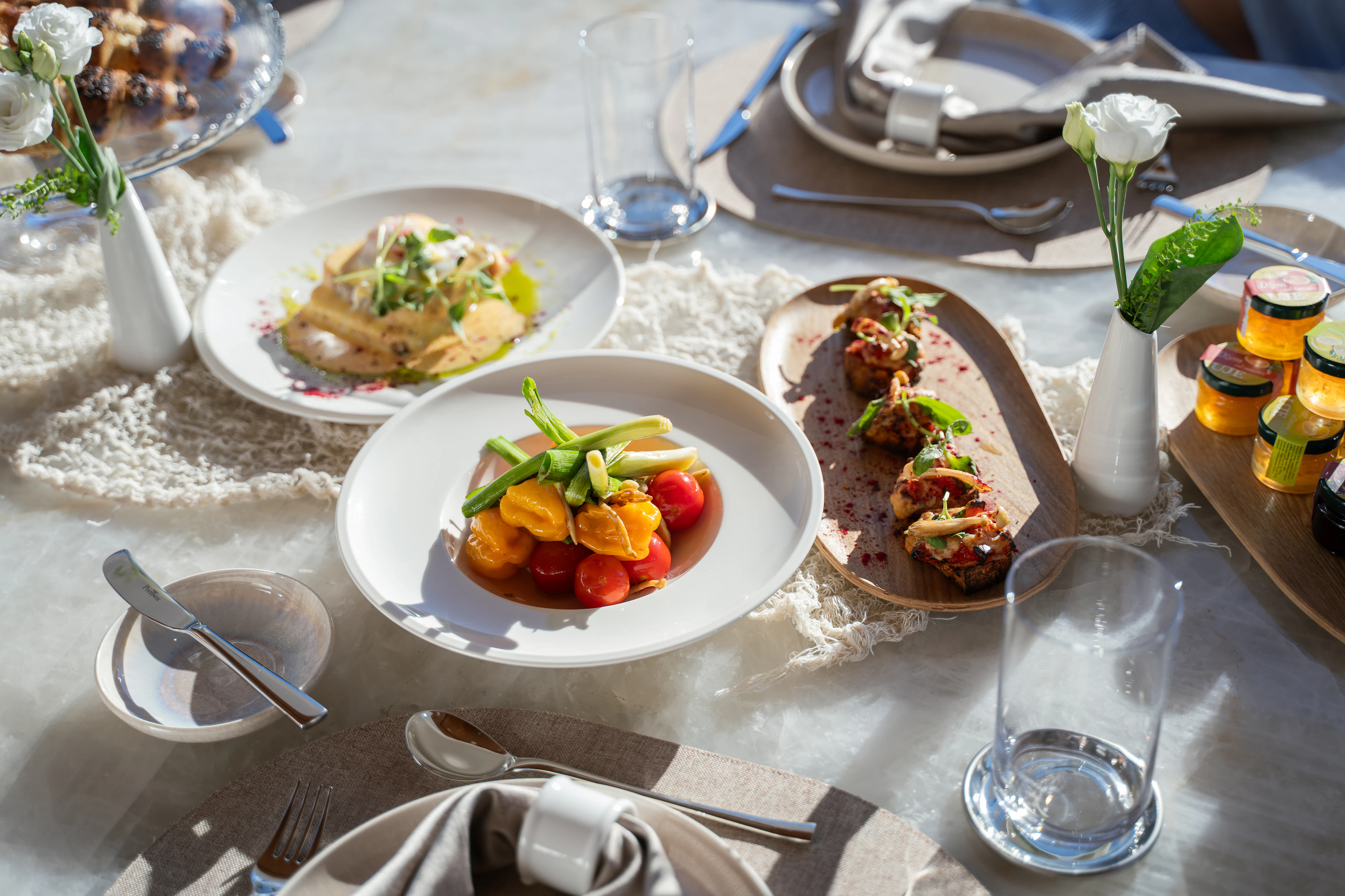 a table with plates of food and glasses aboard RENATA Yacht for Charter