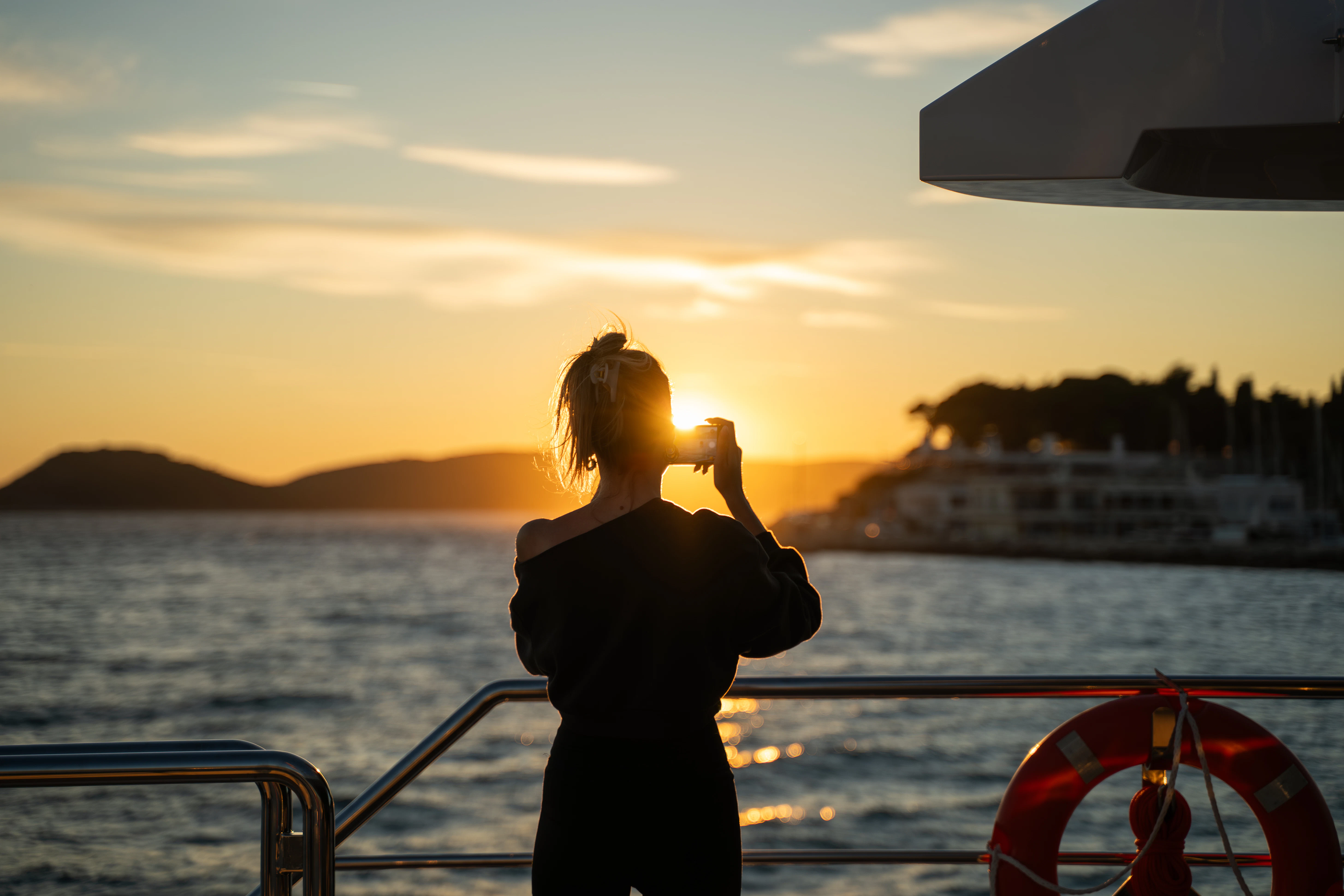 a person standing on a boat and holding a camera aboard RENATA Yacht for Charter