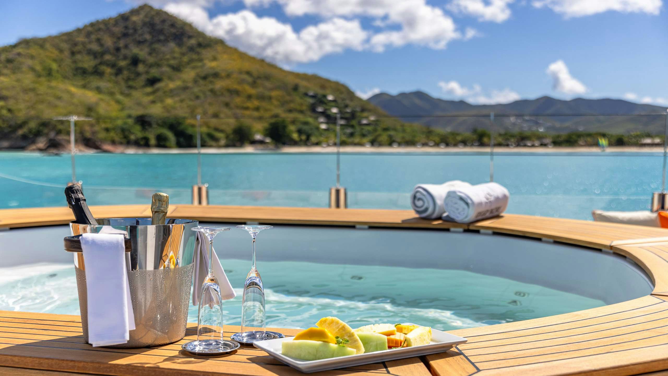 a table with food and glasses on it by a body of water aboard DEEP BLUE Yacht for Charter